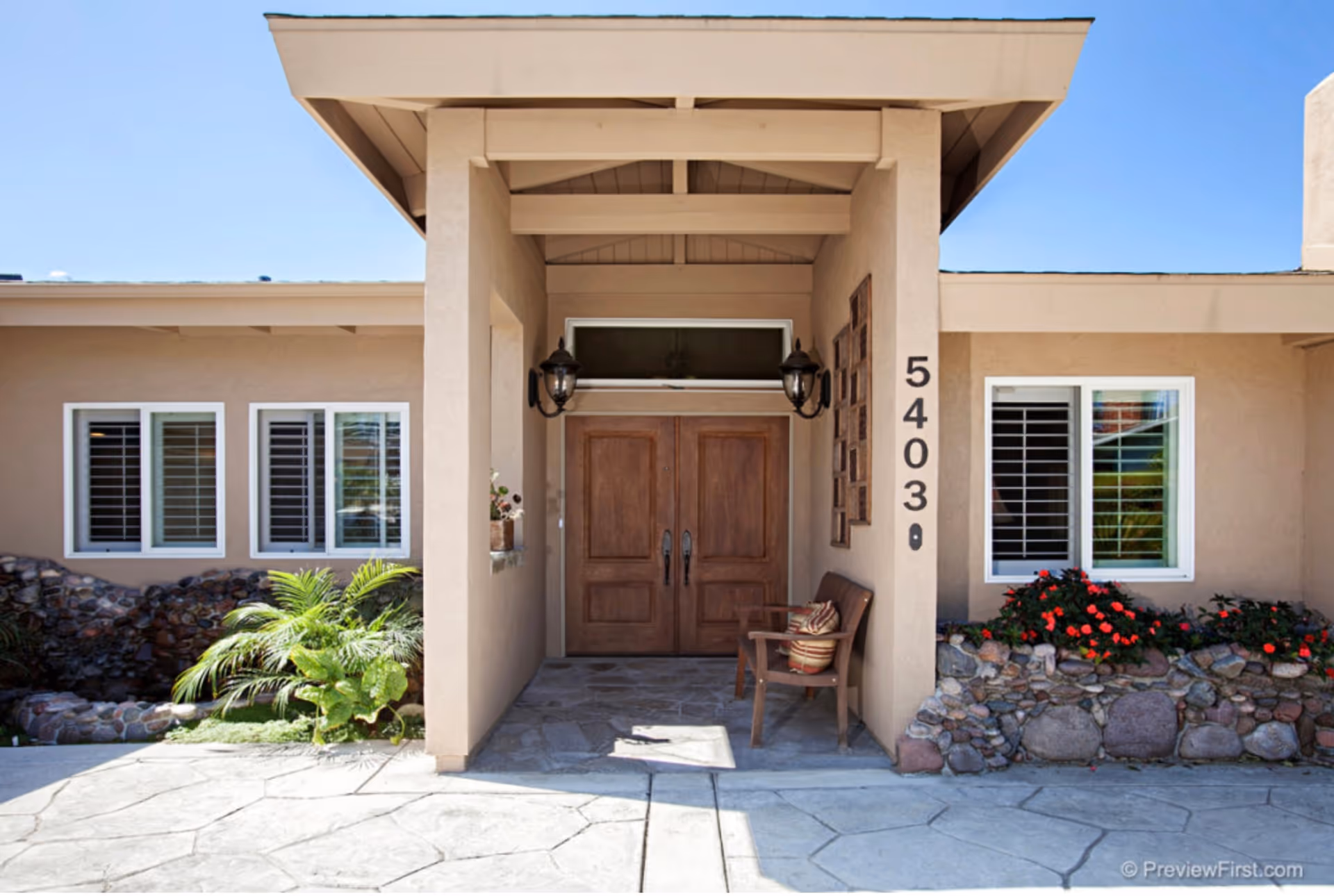 Sea Breeze Senior Living front entrance: tan building, double wooden doors, numbered column 5403