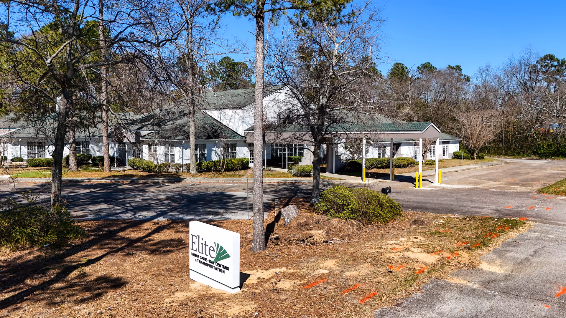 Exterior view of Elite Home Care and Day Centers building with trees and parking.