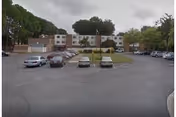 Exterior view of Overture San Marcos senior living building with a parking lot.