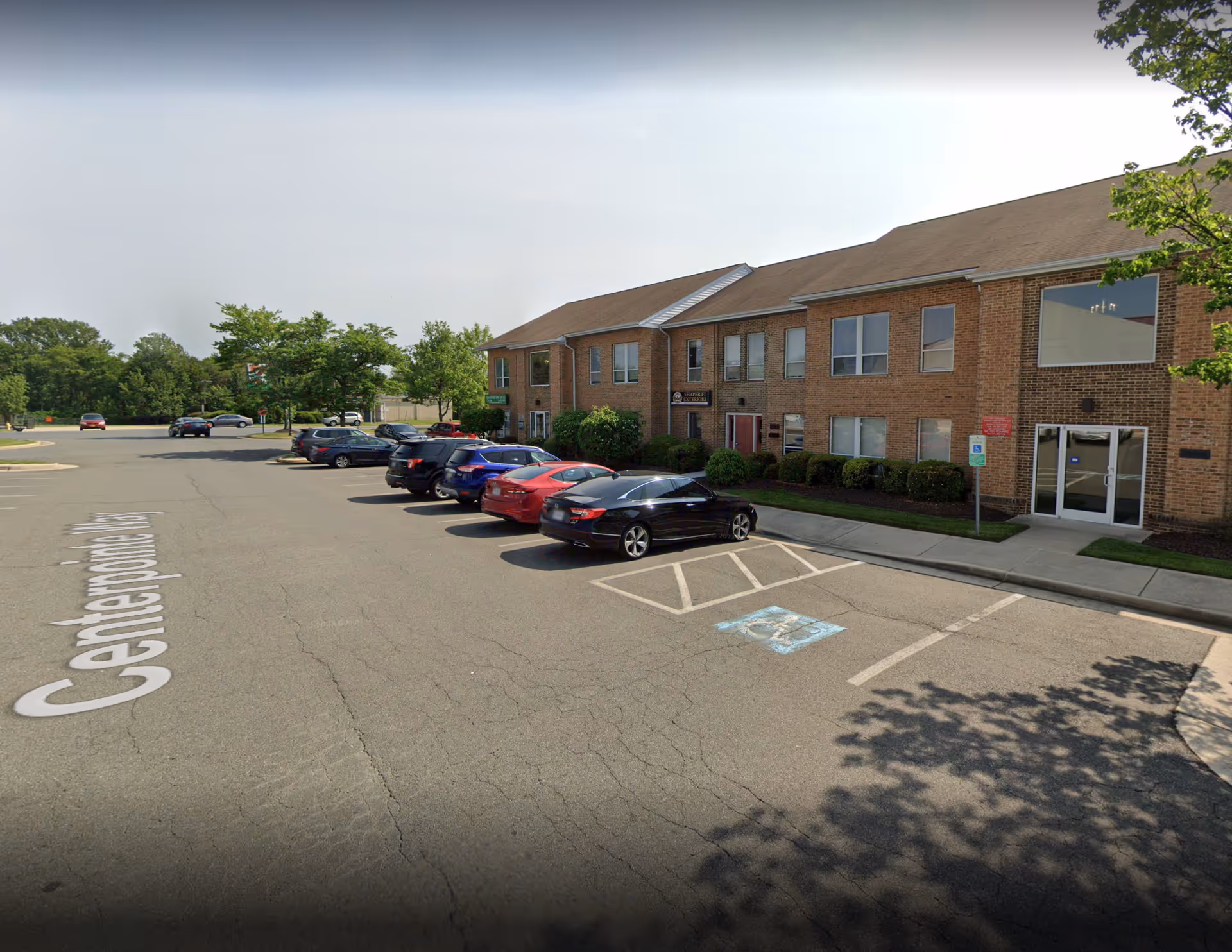 Exterior view of a brick senior living building with a parking lot.