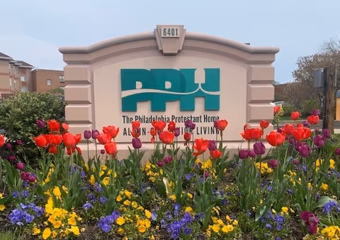 Colorful tulips frame a sign for The Philadelphia Protestant Home at the entrance.