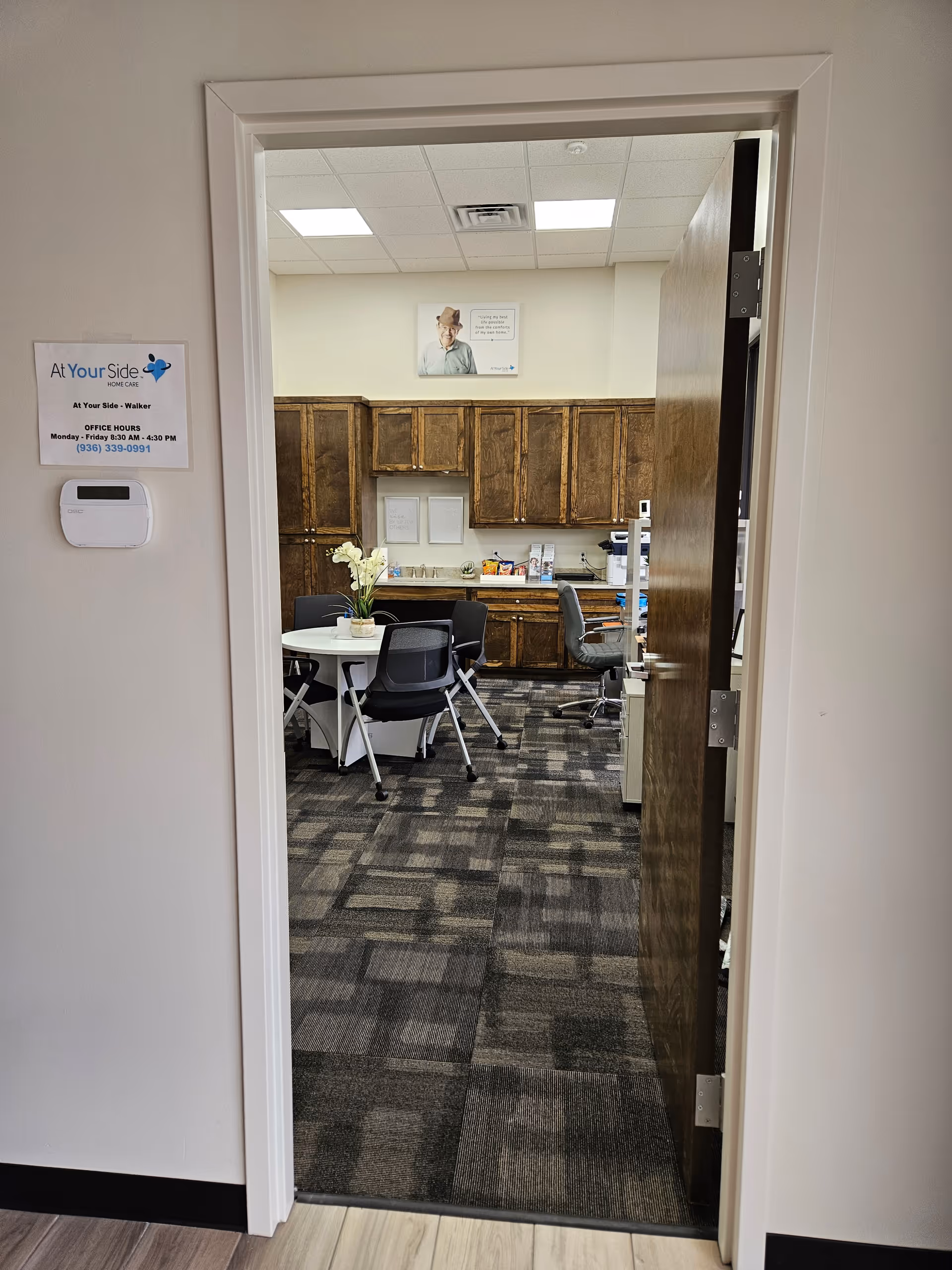 Open doorway reveals a small dining area with round table, chairs, and wooden cabinets.
