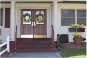 Entrance to Blaire House of Worcester with wreaths on double doors, steps, and potted plants.