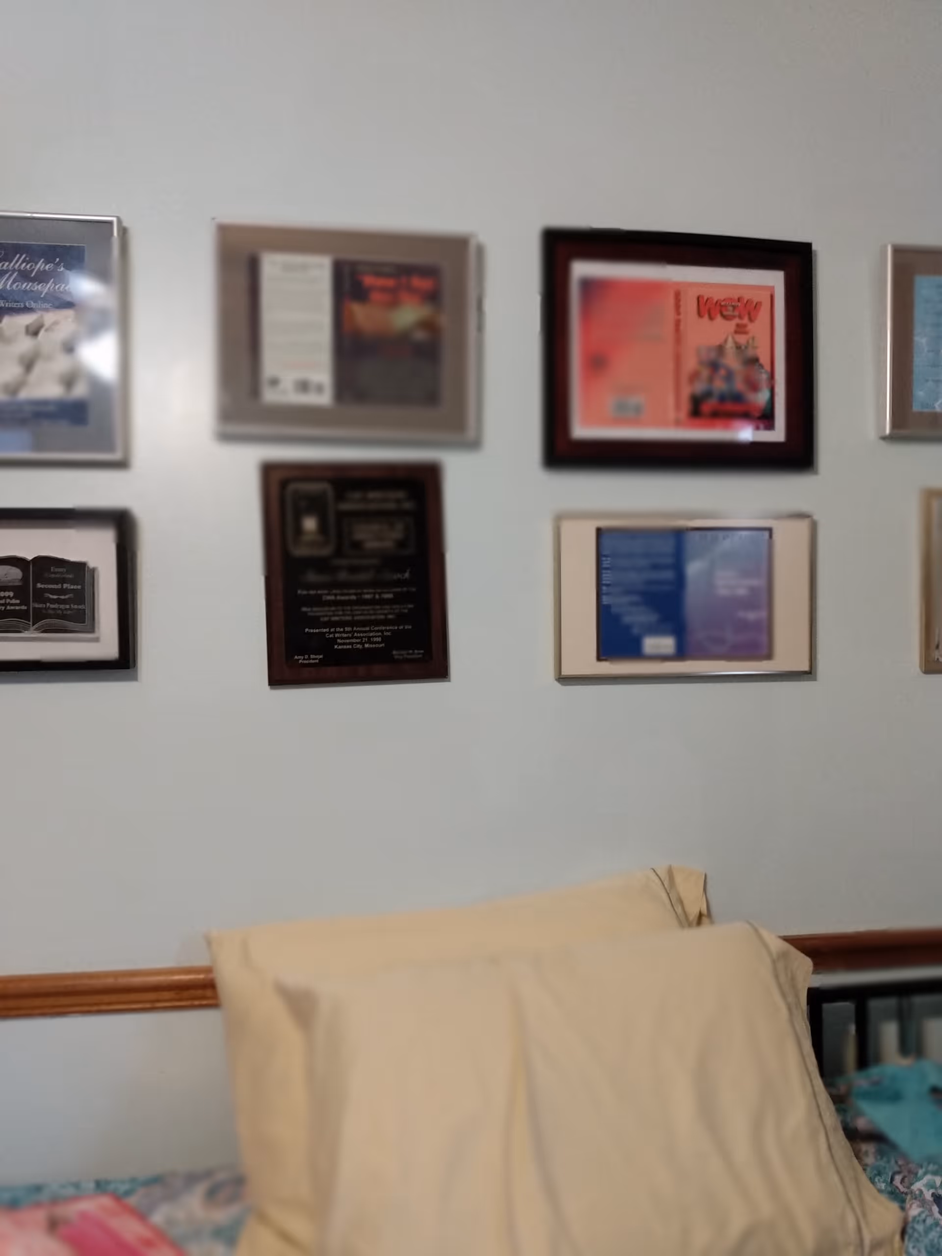 Bedroom wall with framed plaques above a bed in a senior care facility.