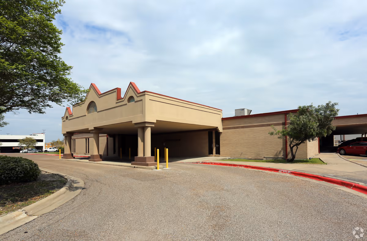 Exterior view of Corpus Christi Healthcare at Home building with entrance drive and pillars.