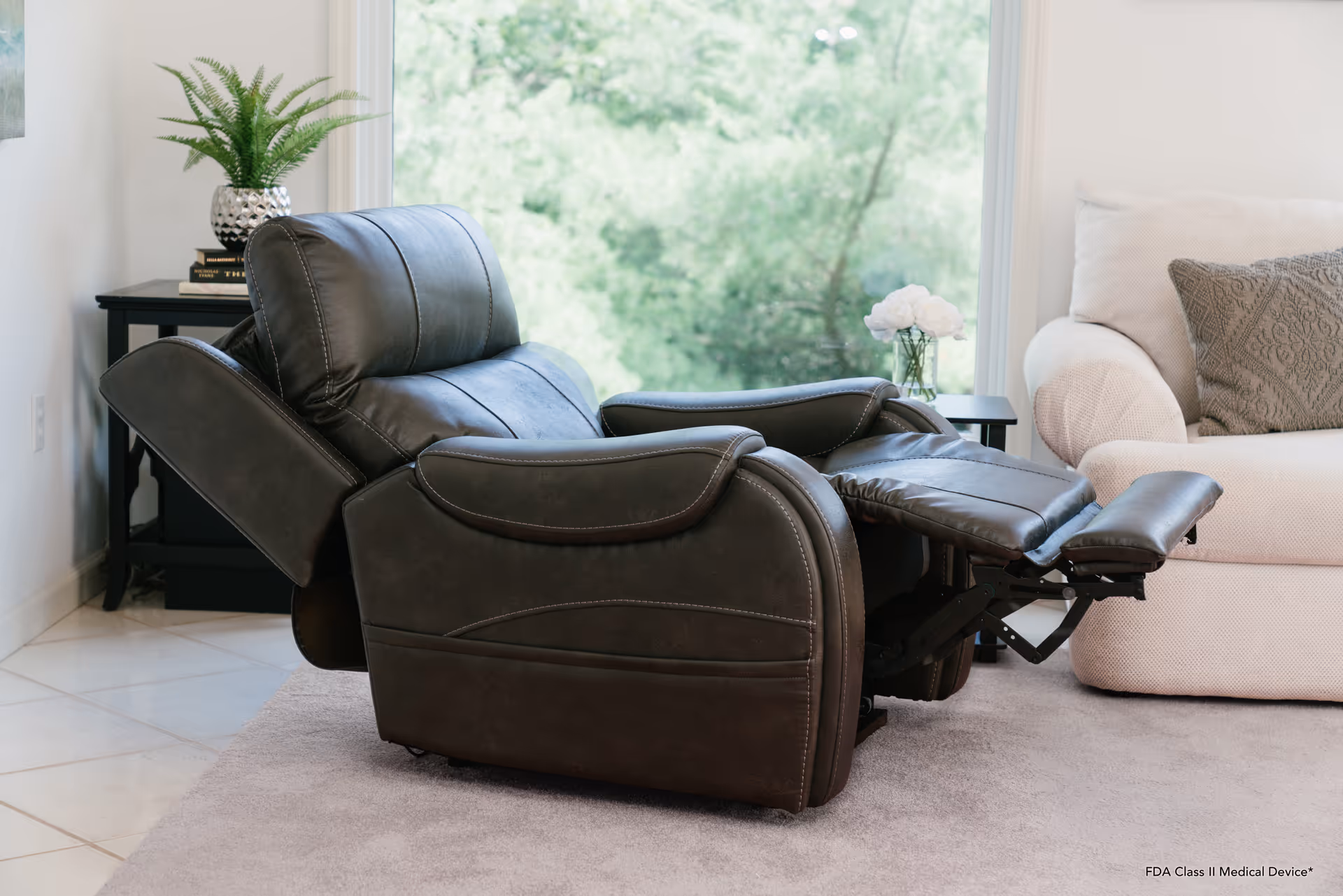A dark leather recliner chair in a bright living room with a beige sofa.