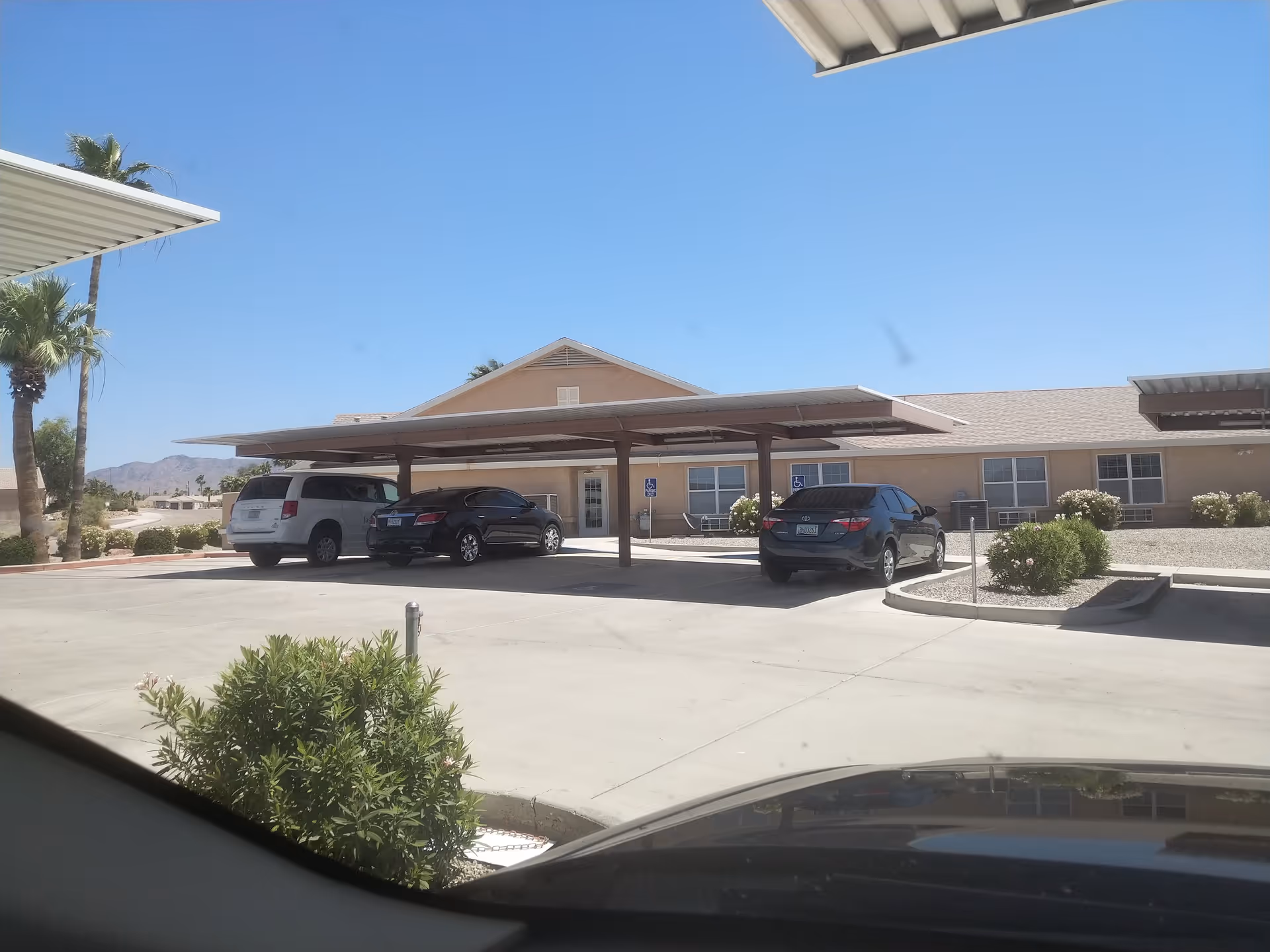 Avista Senior Living Lake Havasu exterior with a covered driveway and parked cars