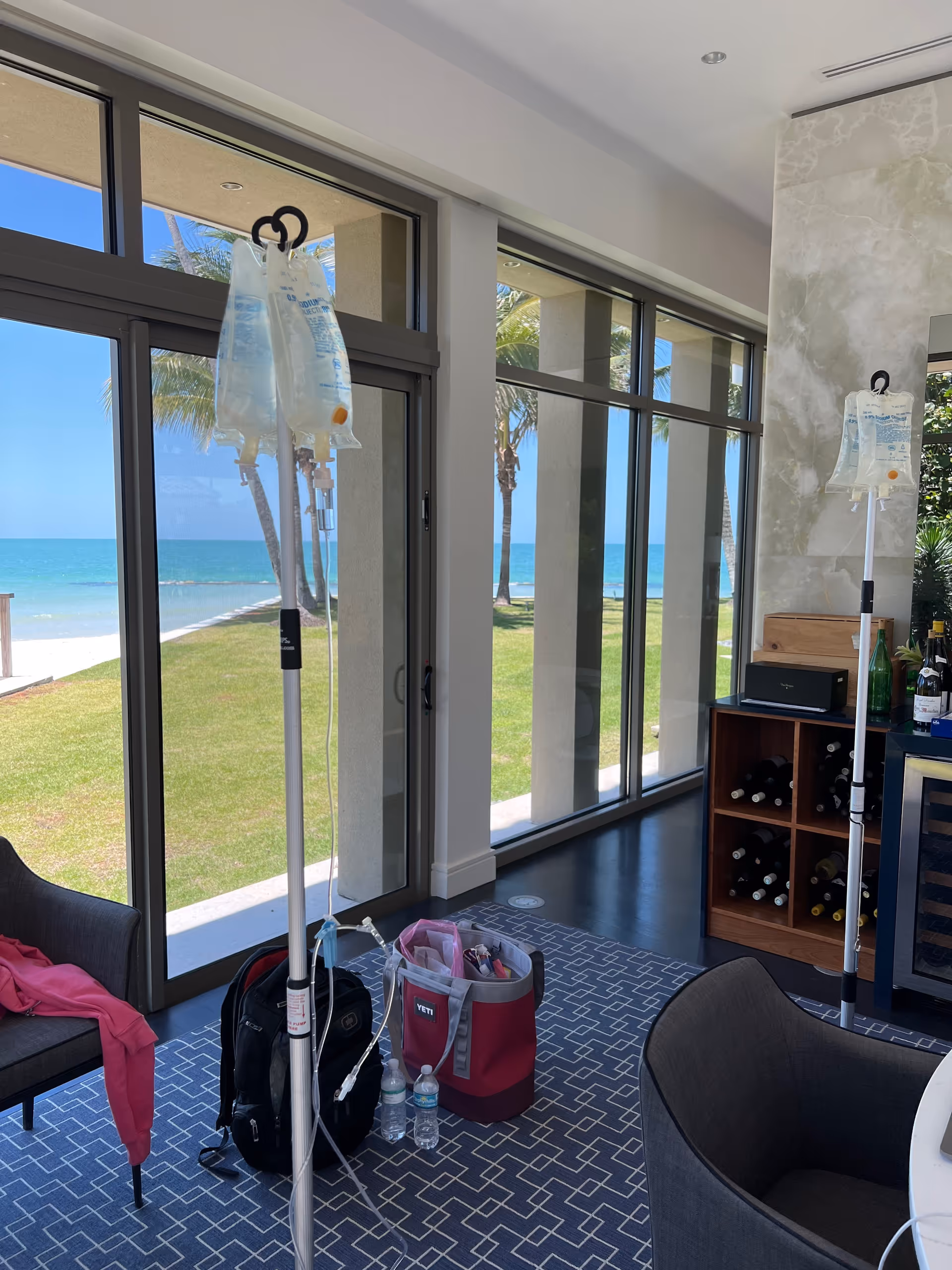 Lounge interior with IV drip stands and beach view windows overlooking the ocean.