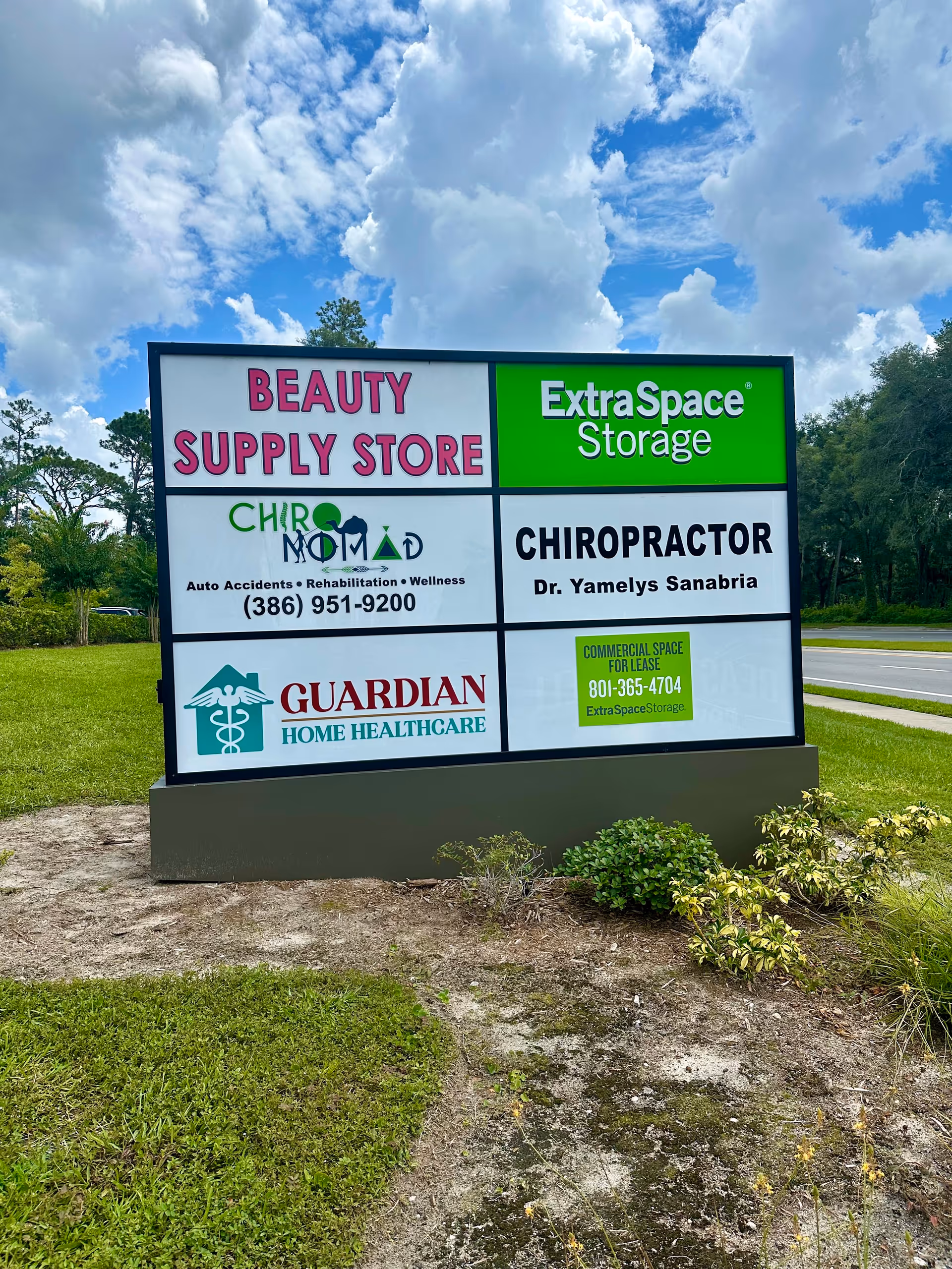 Outdoor signboard displaying multiple business names, including Guardian Home Healthcare.