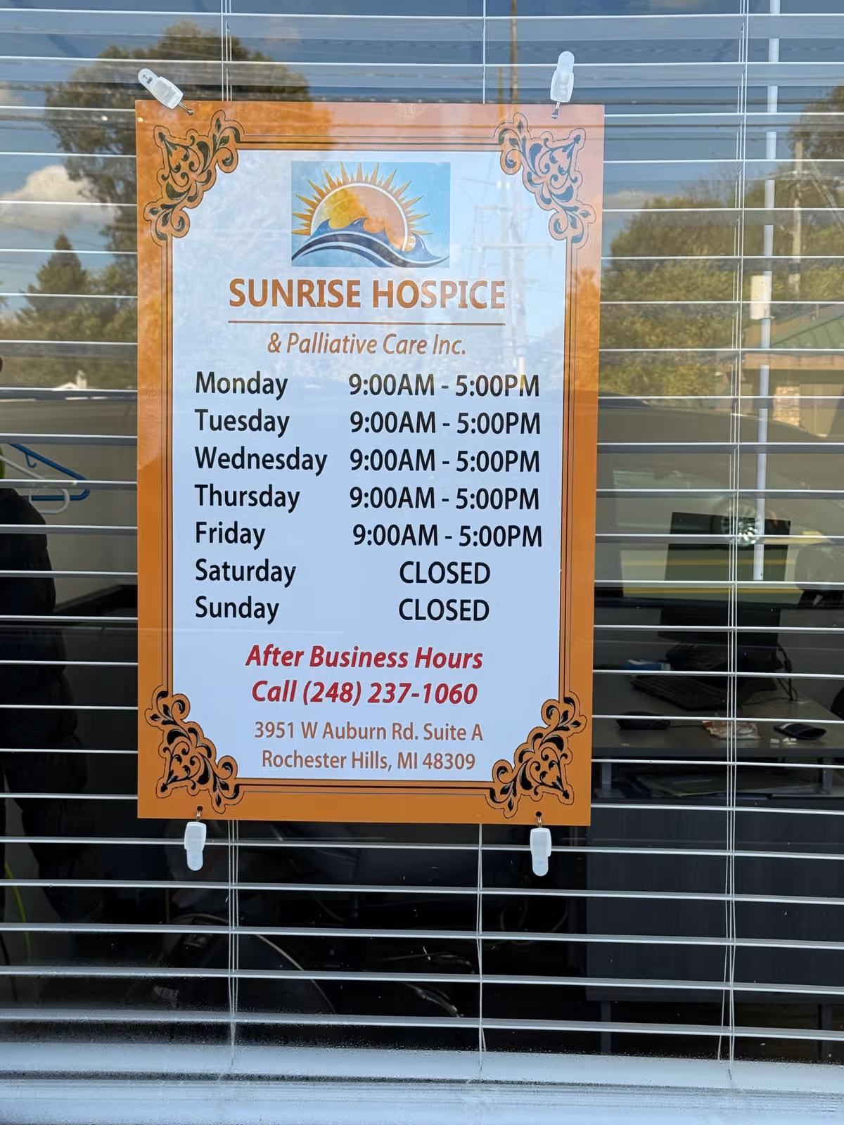 Sunrise Hospice and Palliative Care sign posted on a window with weekly hours.