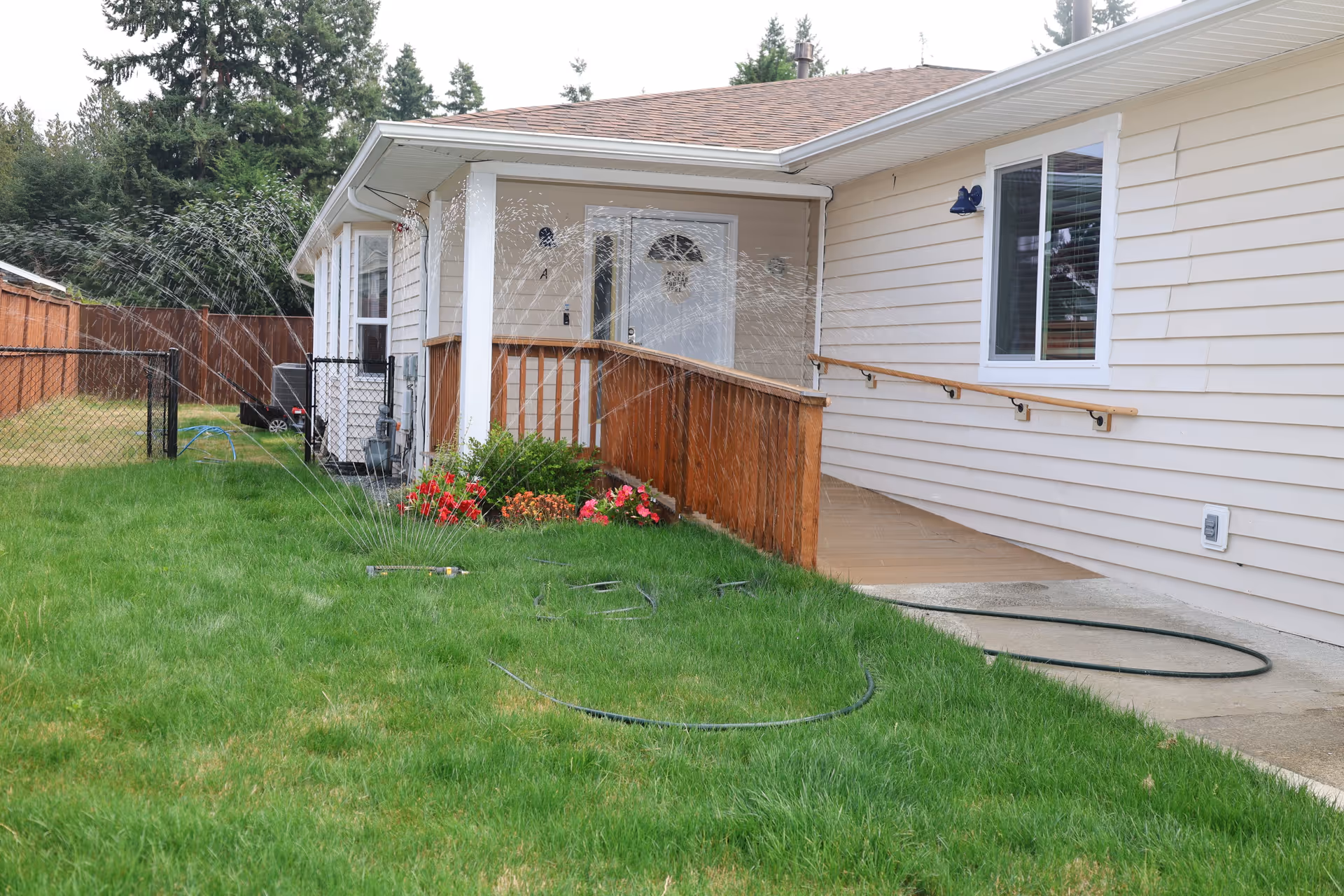 Front view of a single-story house with a ramp, windows, and a green lawn.