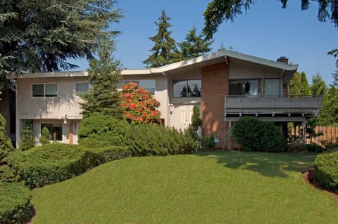 Front exterior of Evergreen Elderly Care I with a manicured lawn and shrubs.