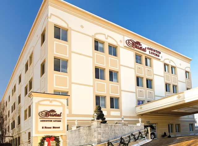 Three-story beige assisted living building with The Bristal sign and decorative entry.