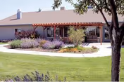 Single-story care center exterior with a covered entrance and landscaped front yard.