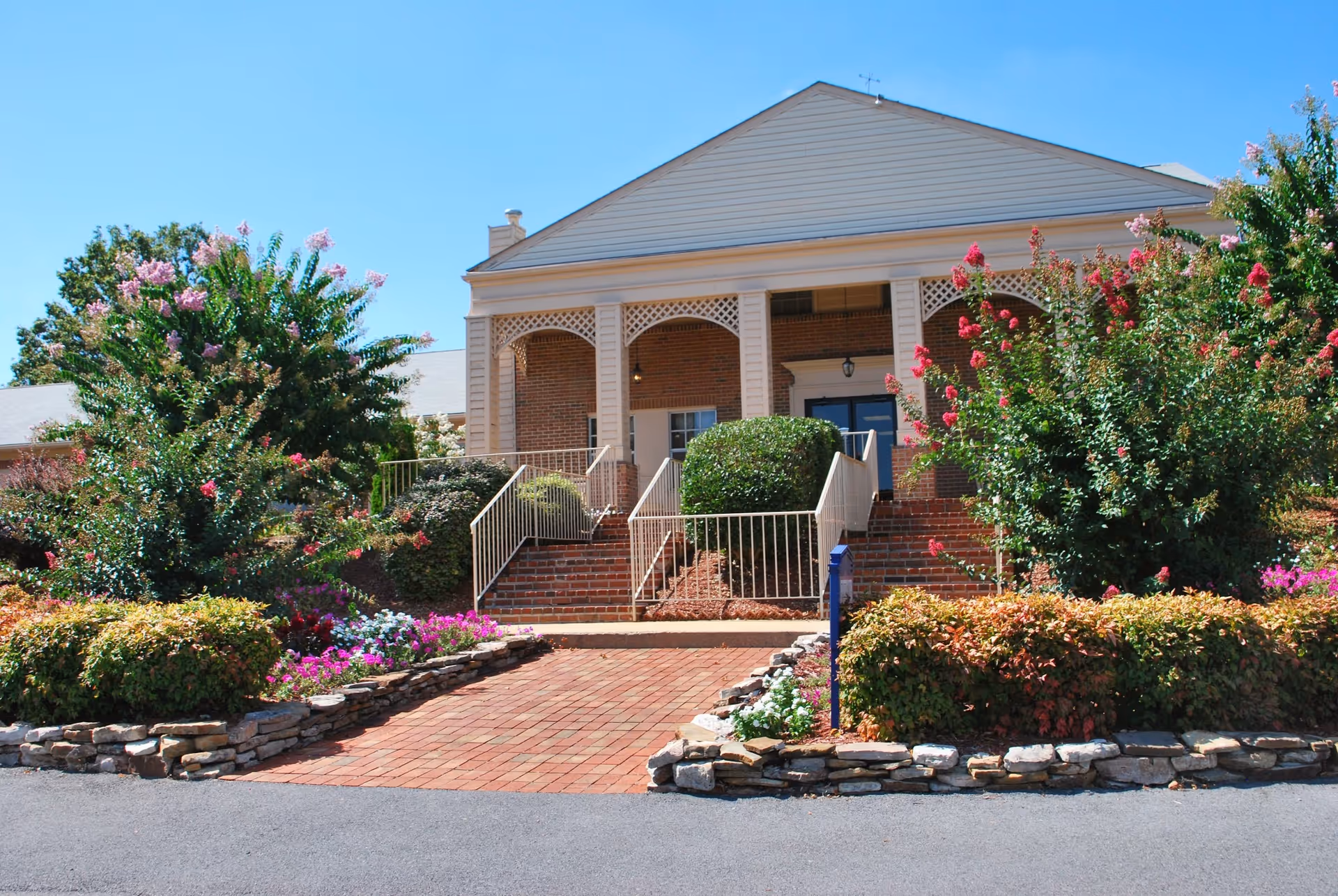 Front entrance of Nhc Healthcare Johnson City with brick steps and landscaped garden.