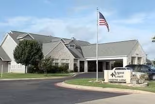 Exterior view of Argent Court Assisted Living building with flagpole and entry sign.