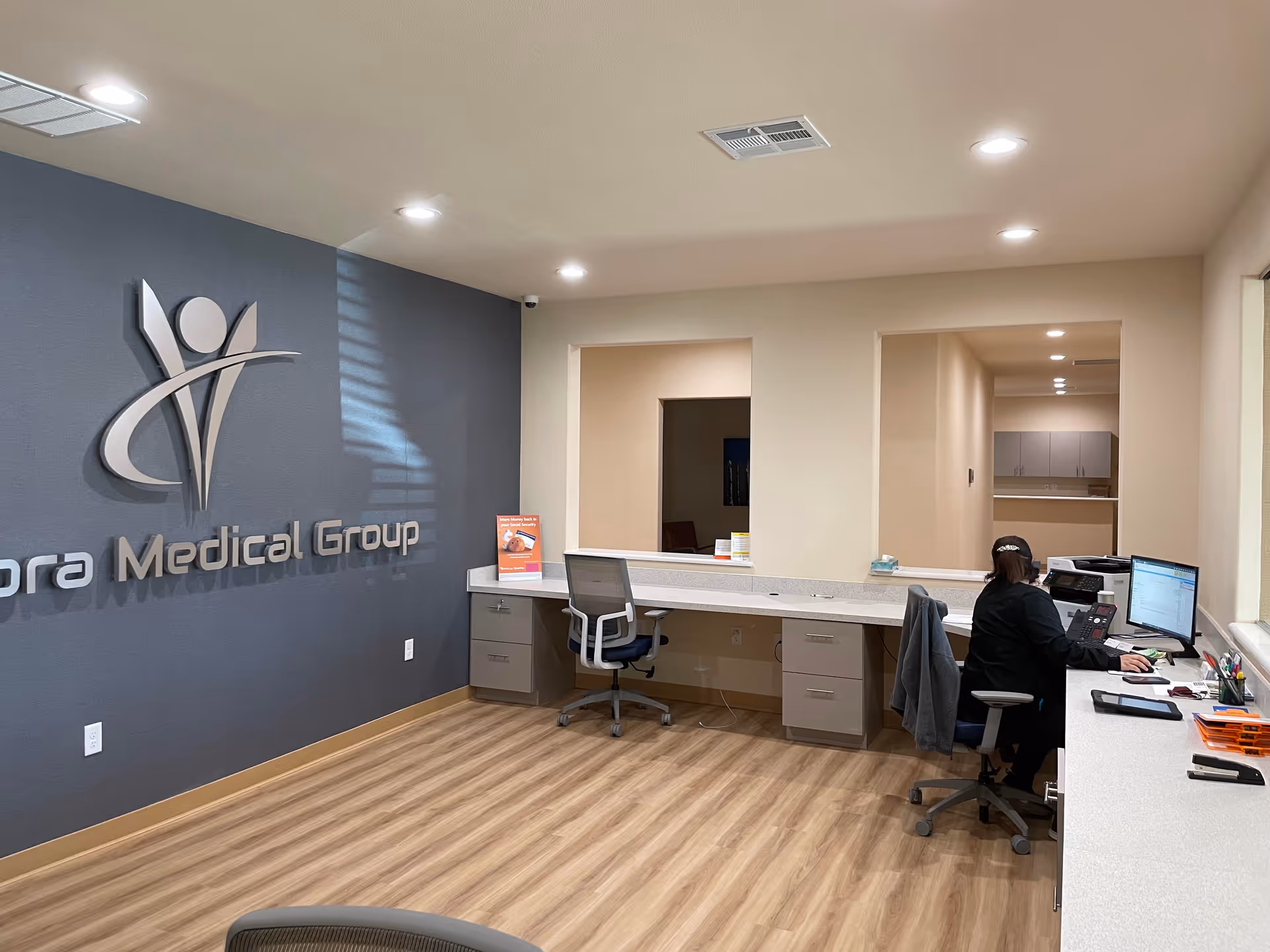 Reception area with Valora Medical Group logo on a blue wall and staff at desks.