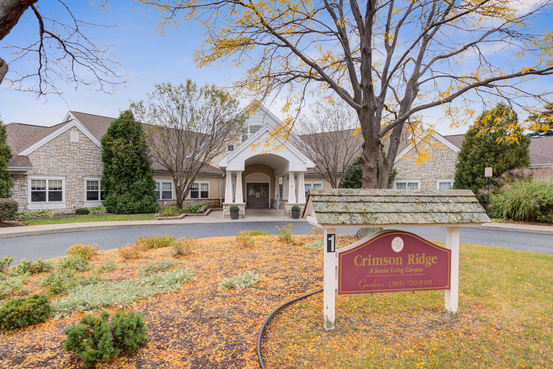 Exterior view of Crimson Ridge Gardens with stone facade, entrance portico, and front sign.