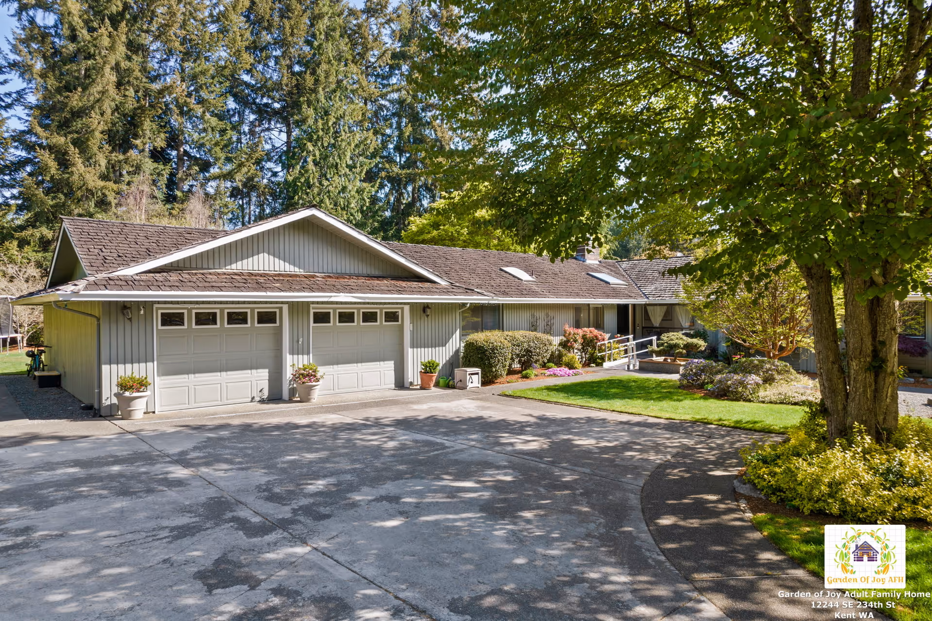 Exterior of a single-story adult family home with three garage bays and a landscaped front yard.