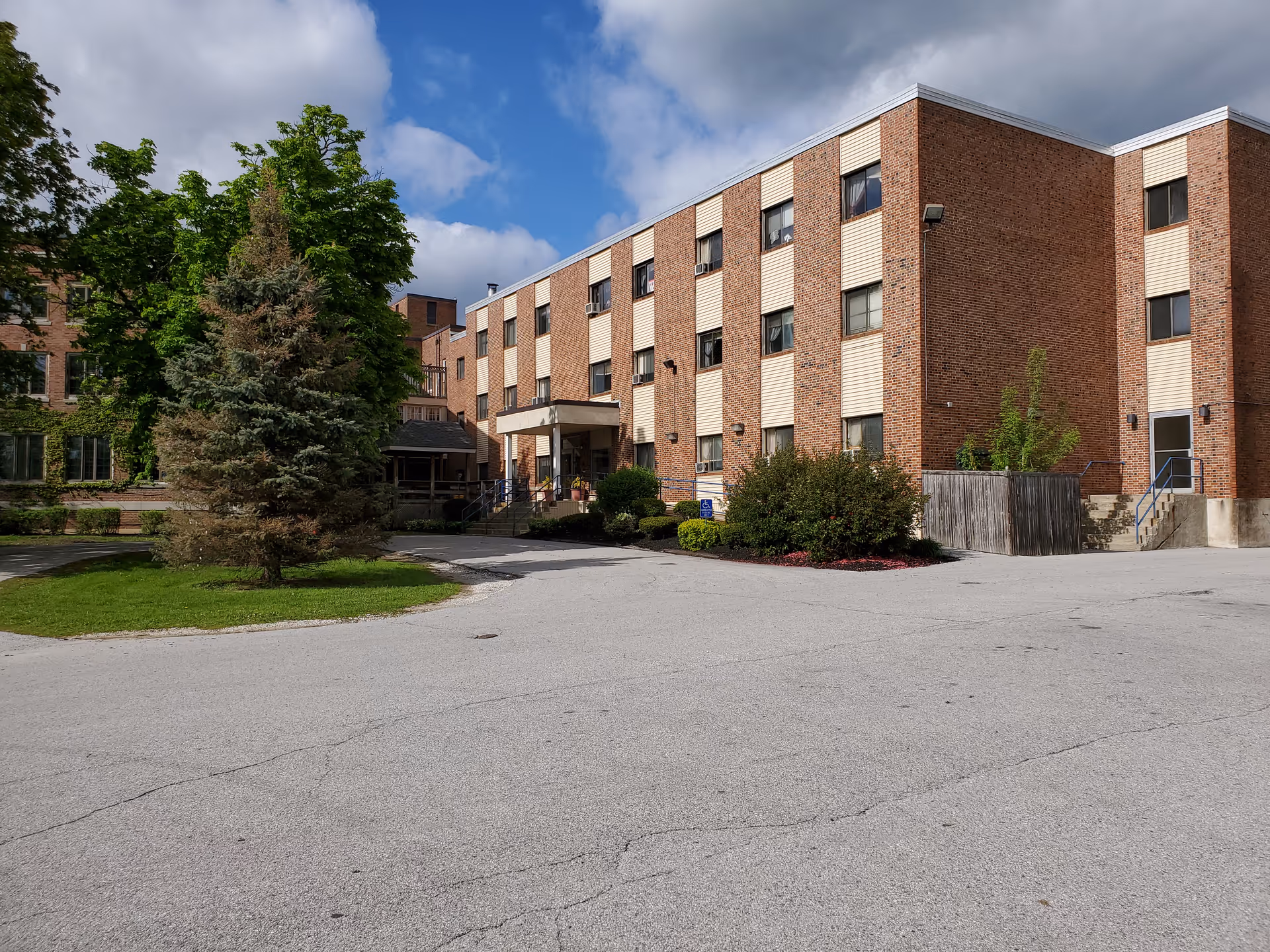 Rutland Center for Living and Rehabilitation exterior with brick facade, entrance, and surrounding trees.