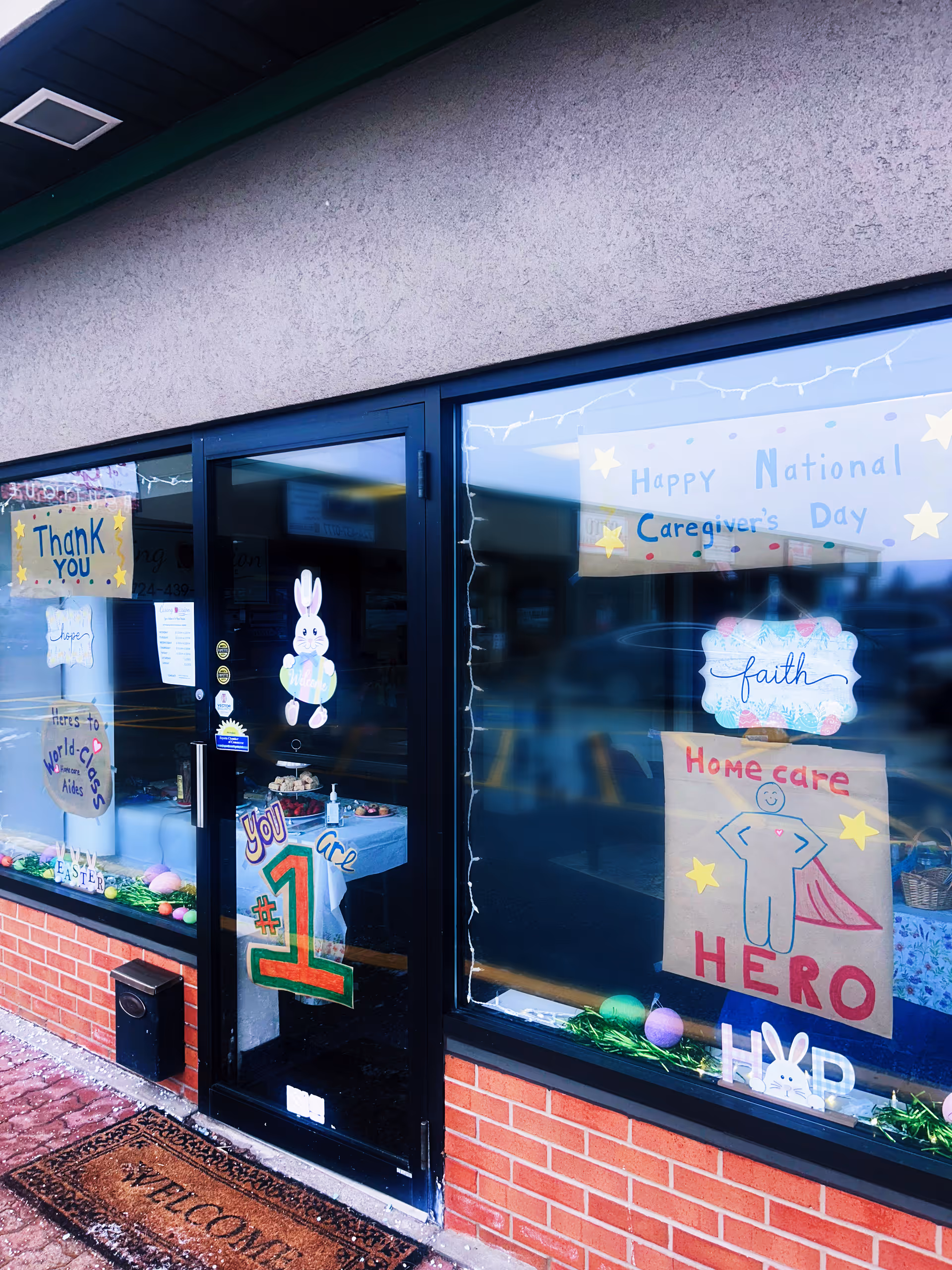 Entrance to Caring Mission Home Care with window posters celebrating National Caregivers Day.