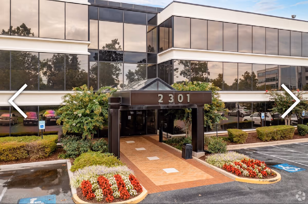 Modern glass-front clinic with a covered entrance and landscaped walkway.