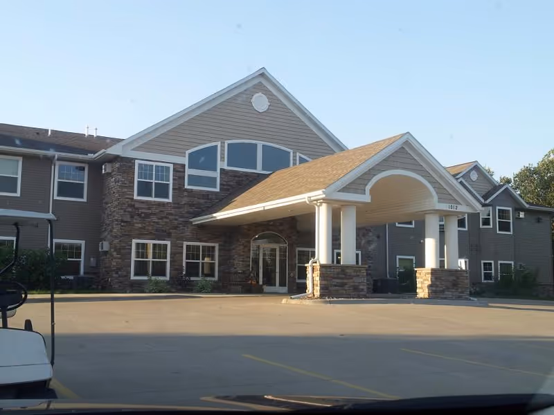 Front view of Highland Senior Living facility with covered entrance and stone accents.