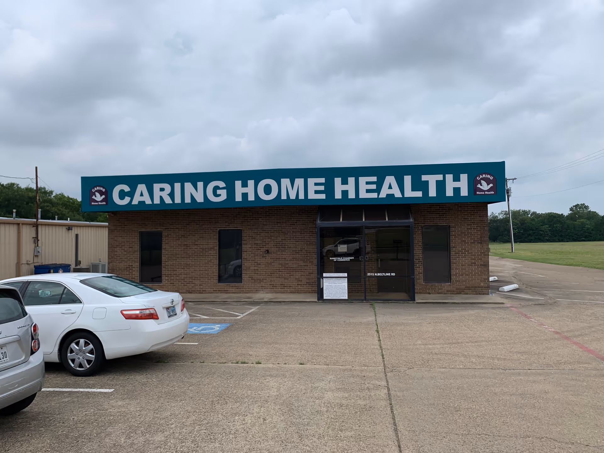 Front view of Caring Home Health facility with parking lot and sign