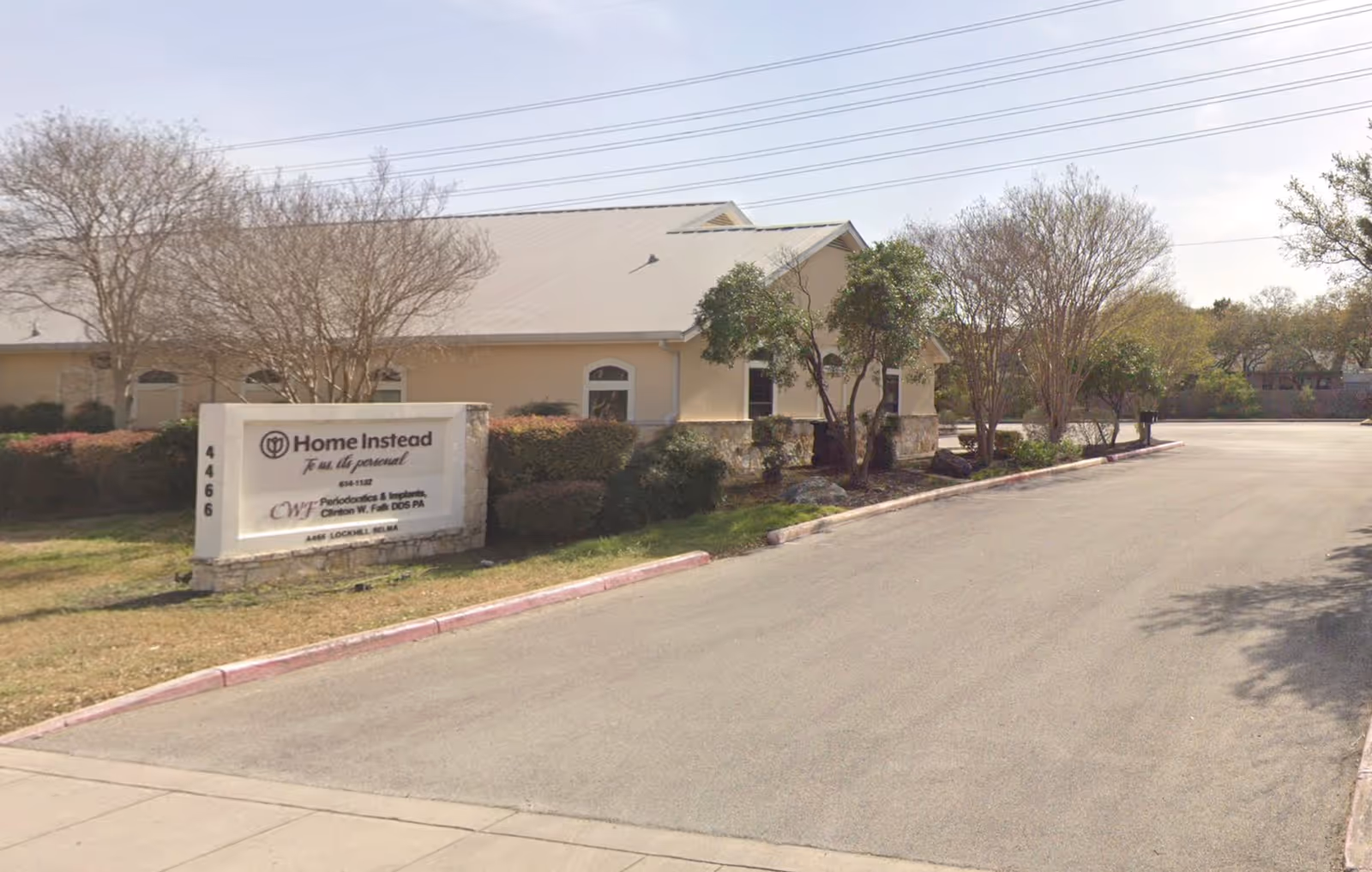 Exterior view of Home Instead facility in San Antonio with sign and driveway