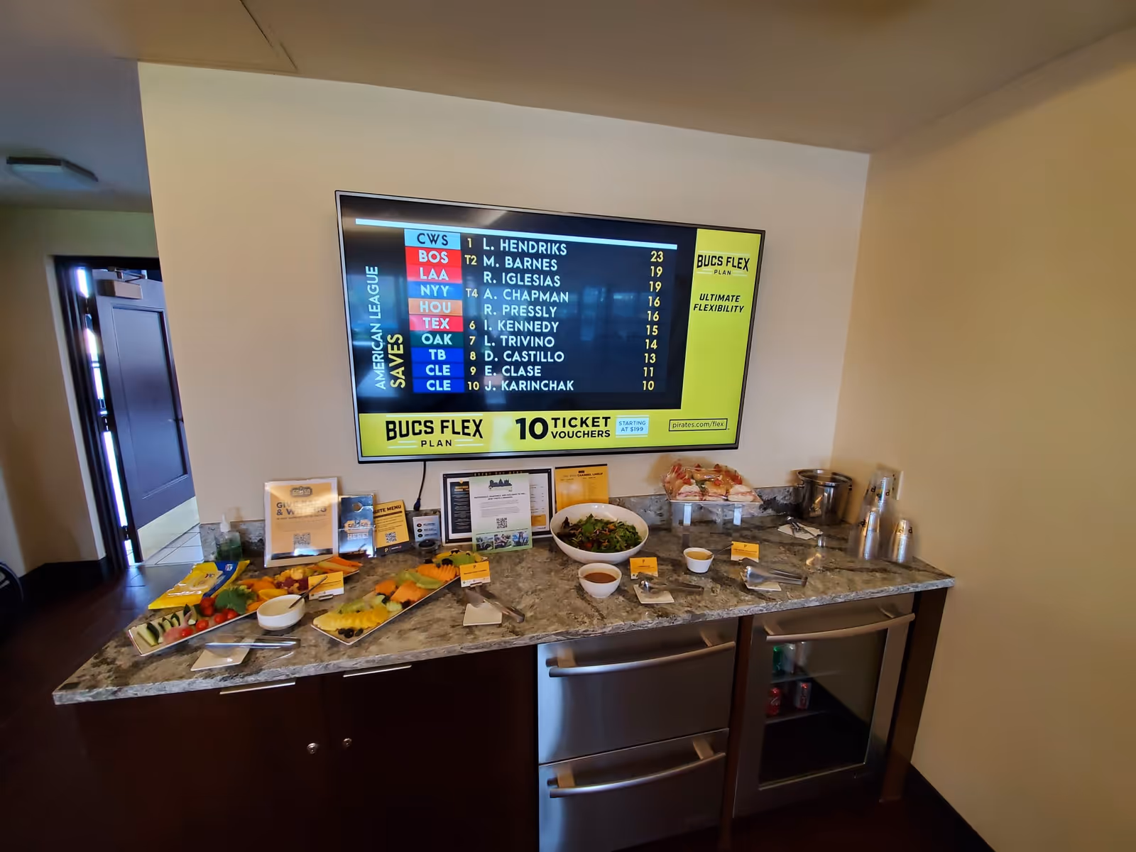 Interior lounge area with a granite counter buffet and a wall-mounted screen.