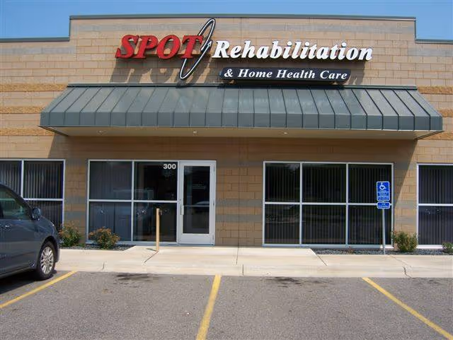 Front exterior of SPOT Rehabilitation and Home Health Care building with entrance and parking.