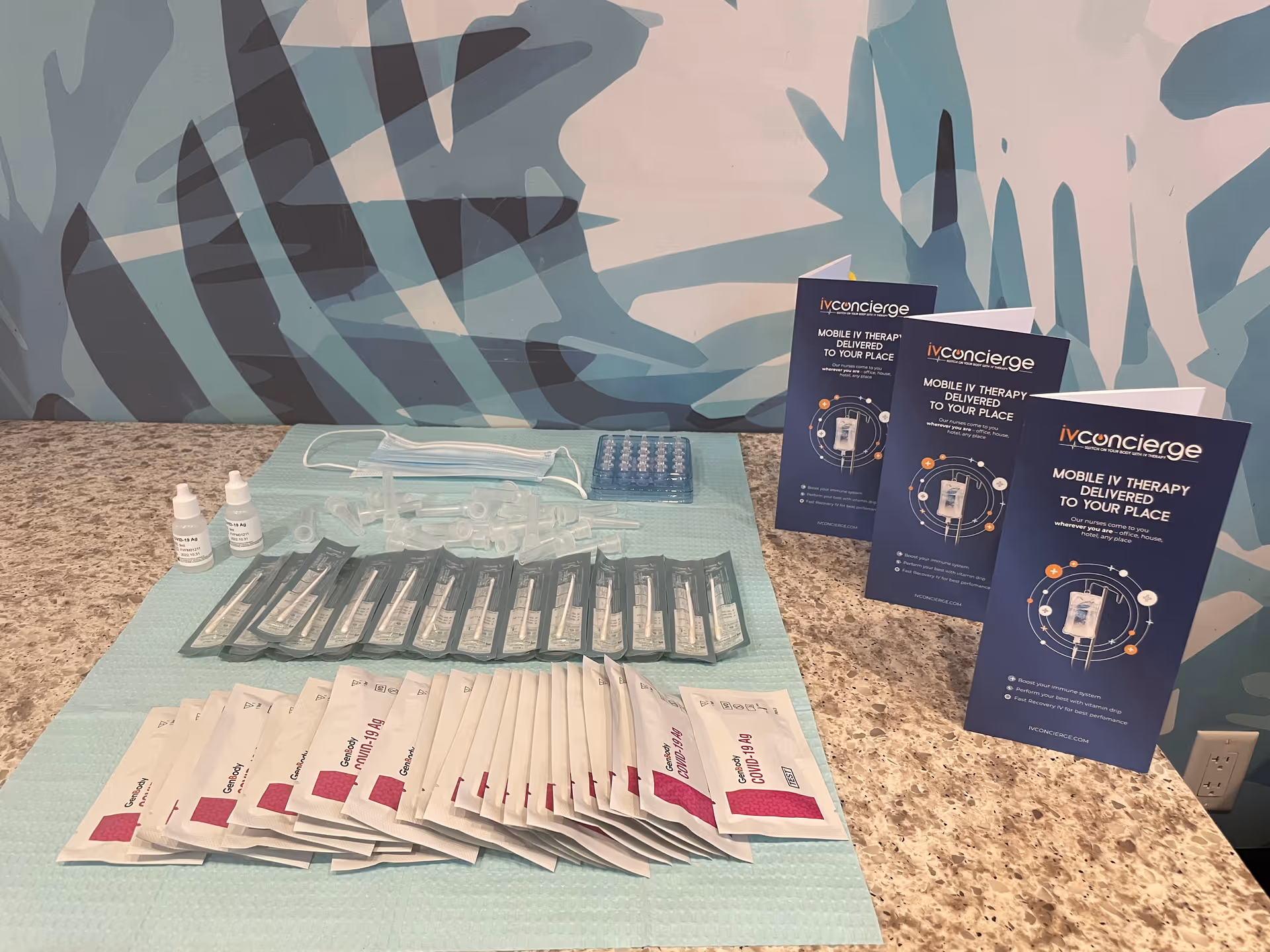 IV therapy supplies and IV Concierge brochures arranged on a granite counter inside a facility.
