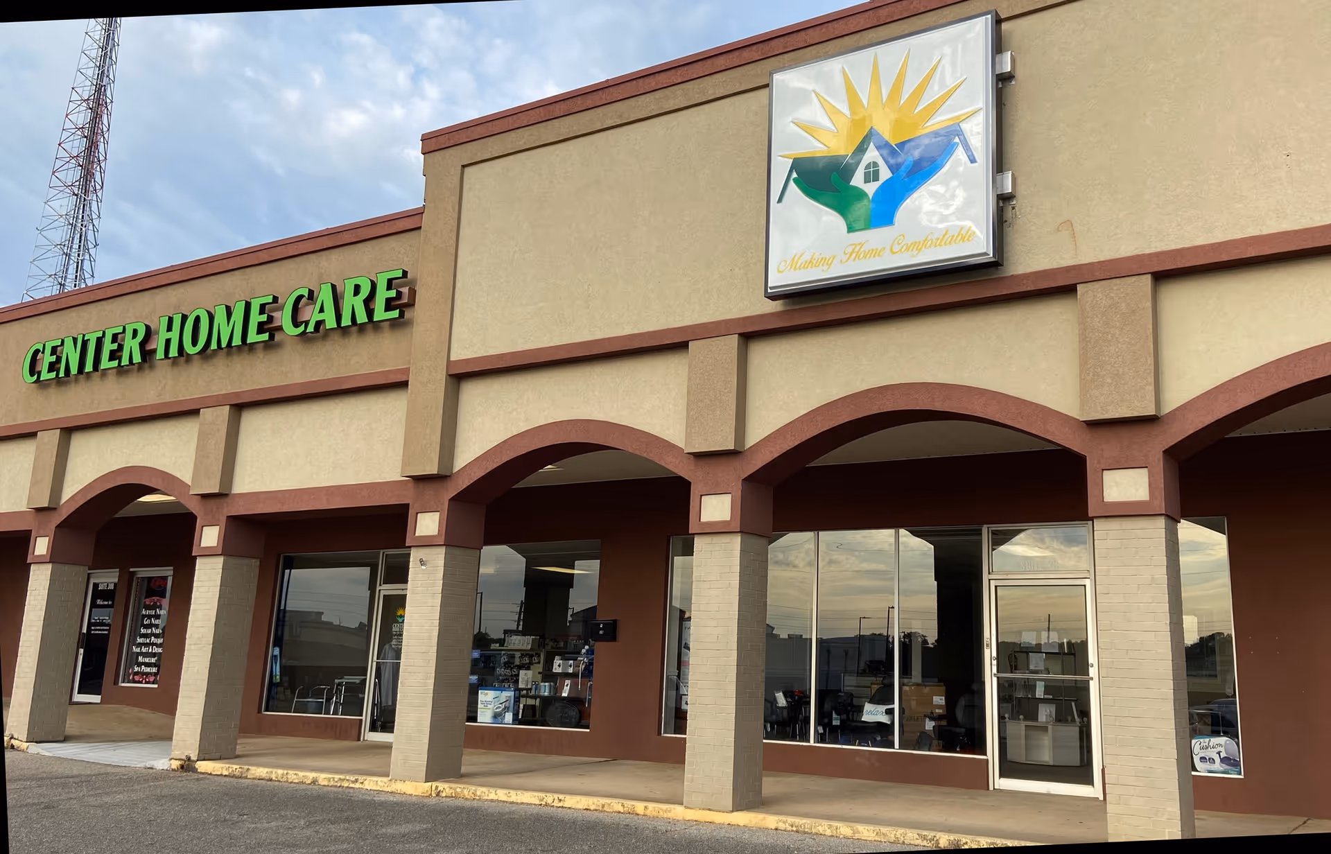 Exterior view of Center Home Care LLC building with green sign and arched storefronts.