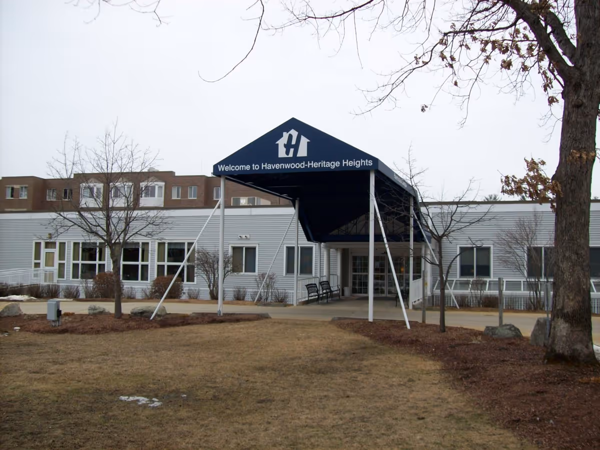 Exterior view of Havenwood Heritage Heights building front with blue entrance canopy
