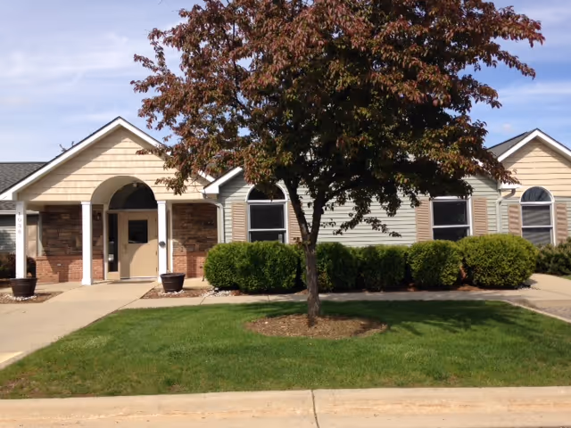 Front view of LoveJoy Community Services senior living facility with a tree and entrance arch.