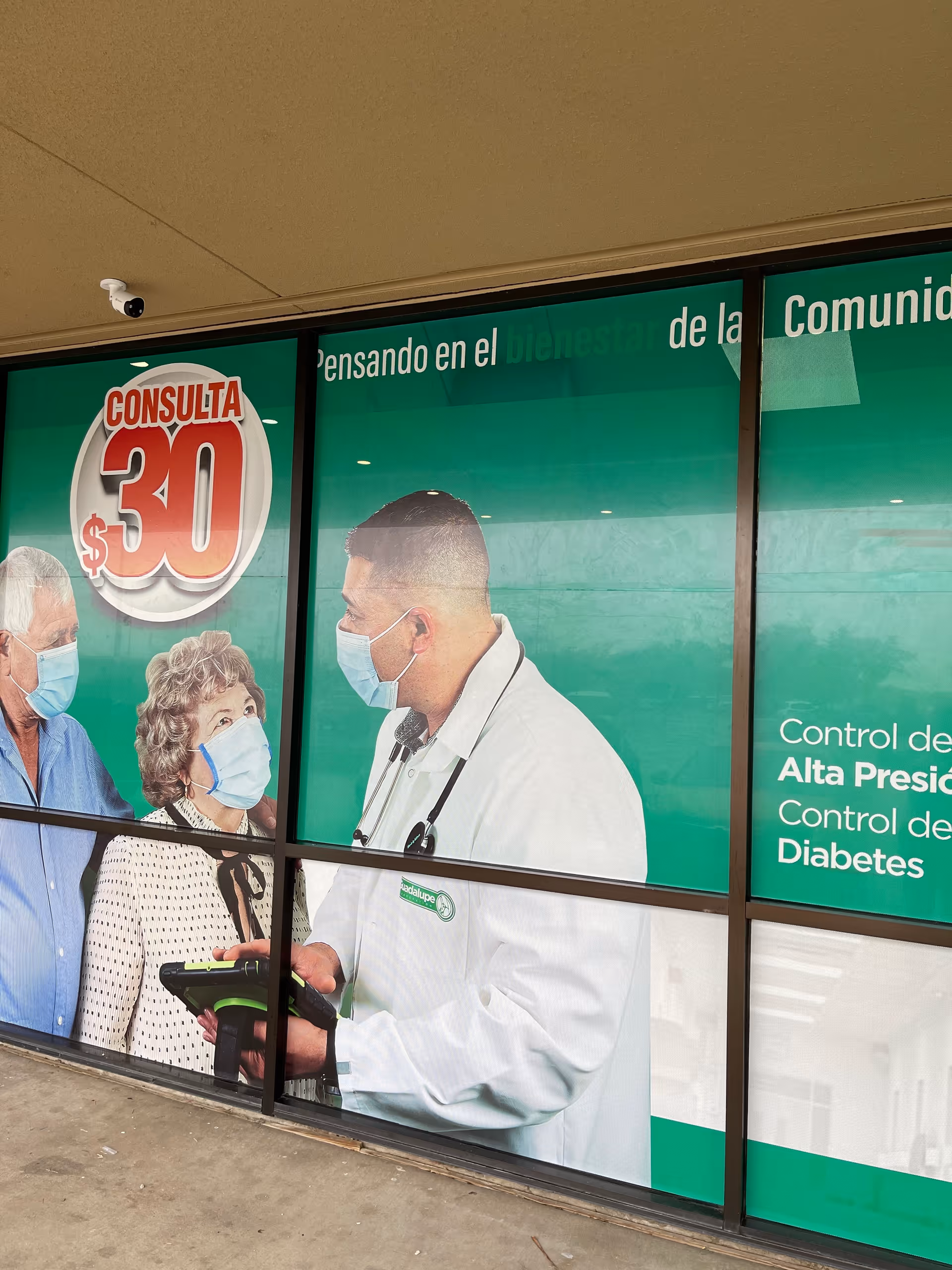 Storefront window with a green medical ad showing a doctor and elderly patients wearing masks.