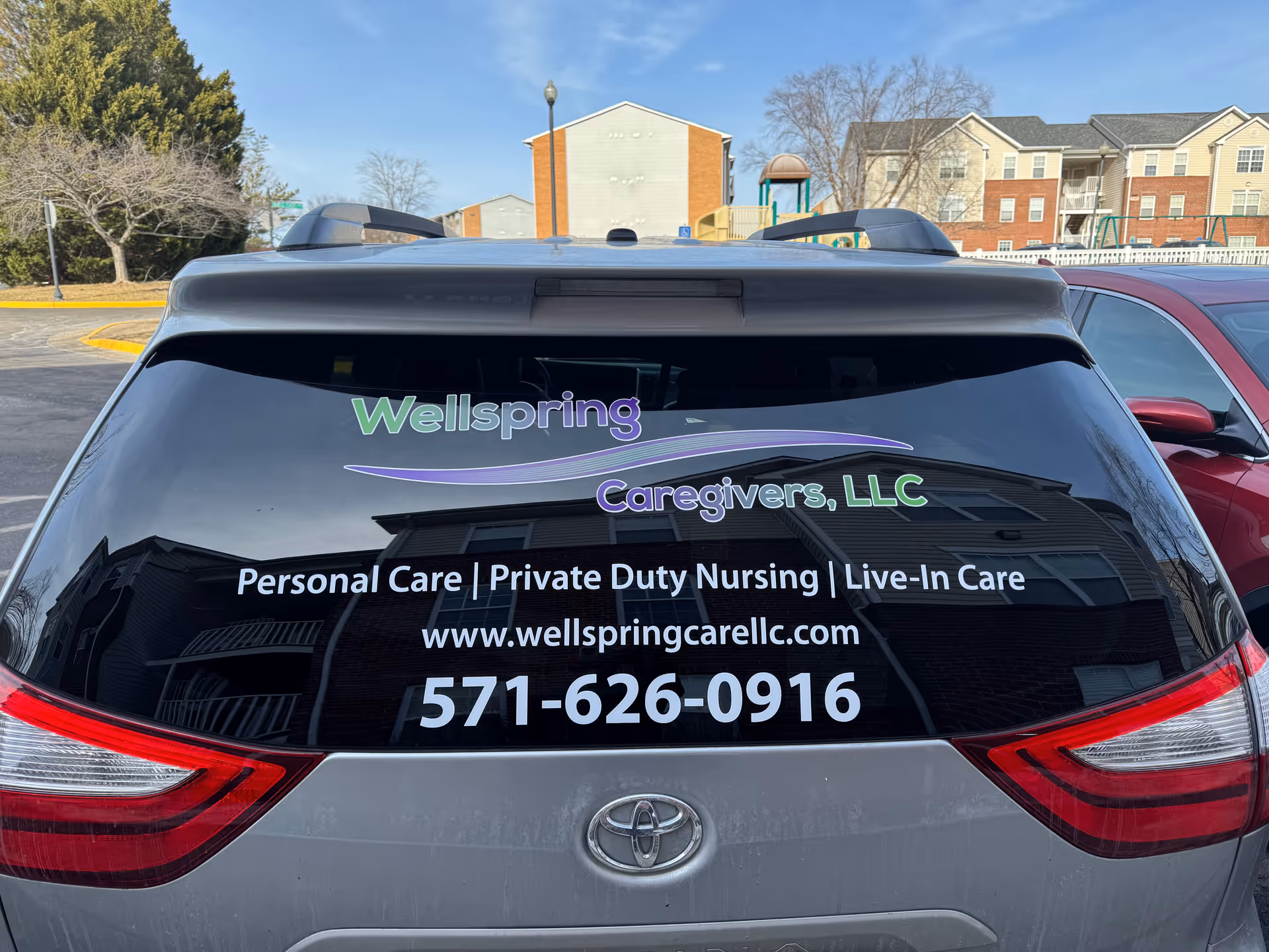 Rear of a vehicle with Wellspring Caregivers, LLC logo and contact details.