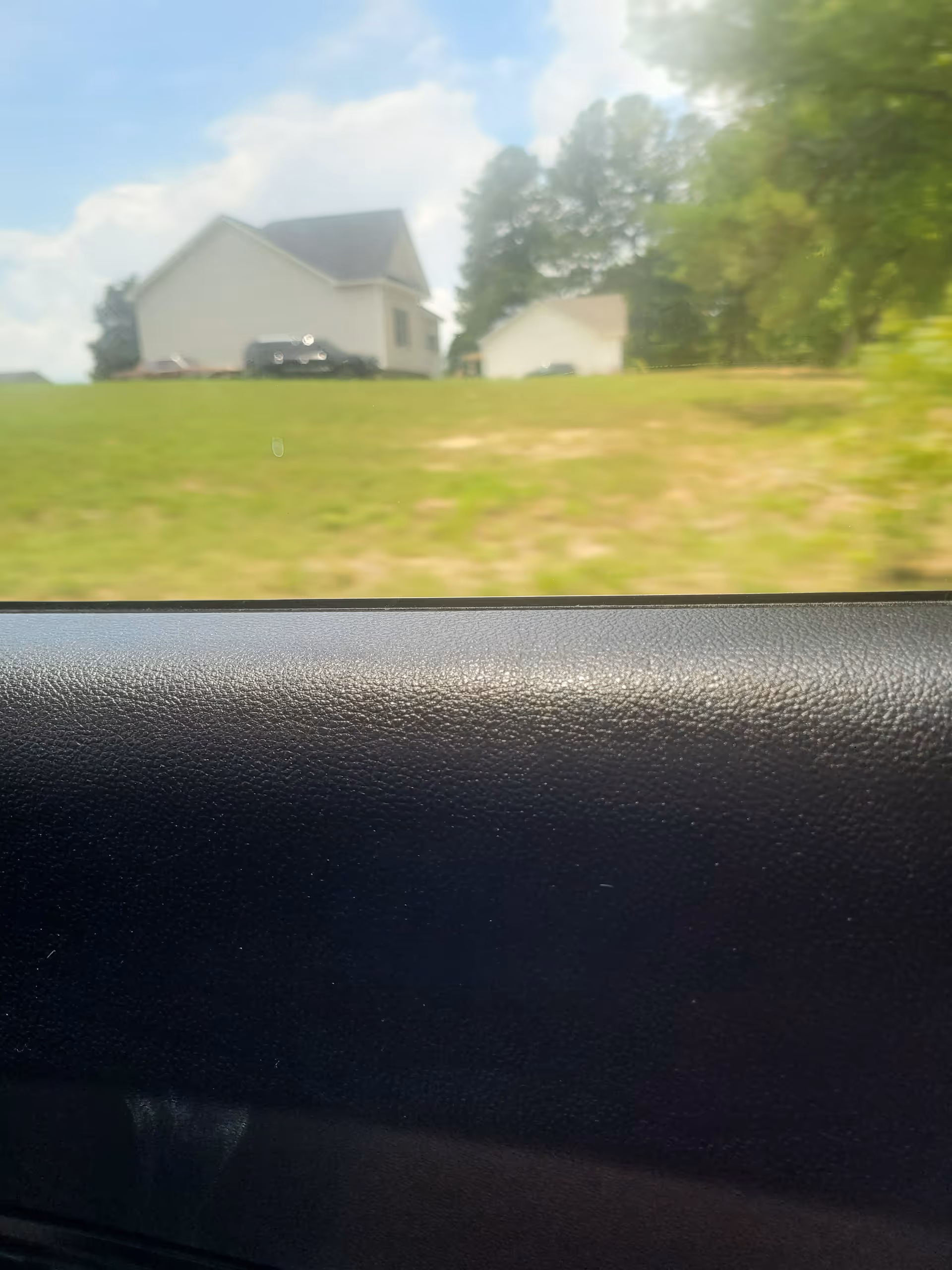Blurry exterior view of a residential building seen from inside a car.