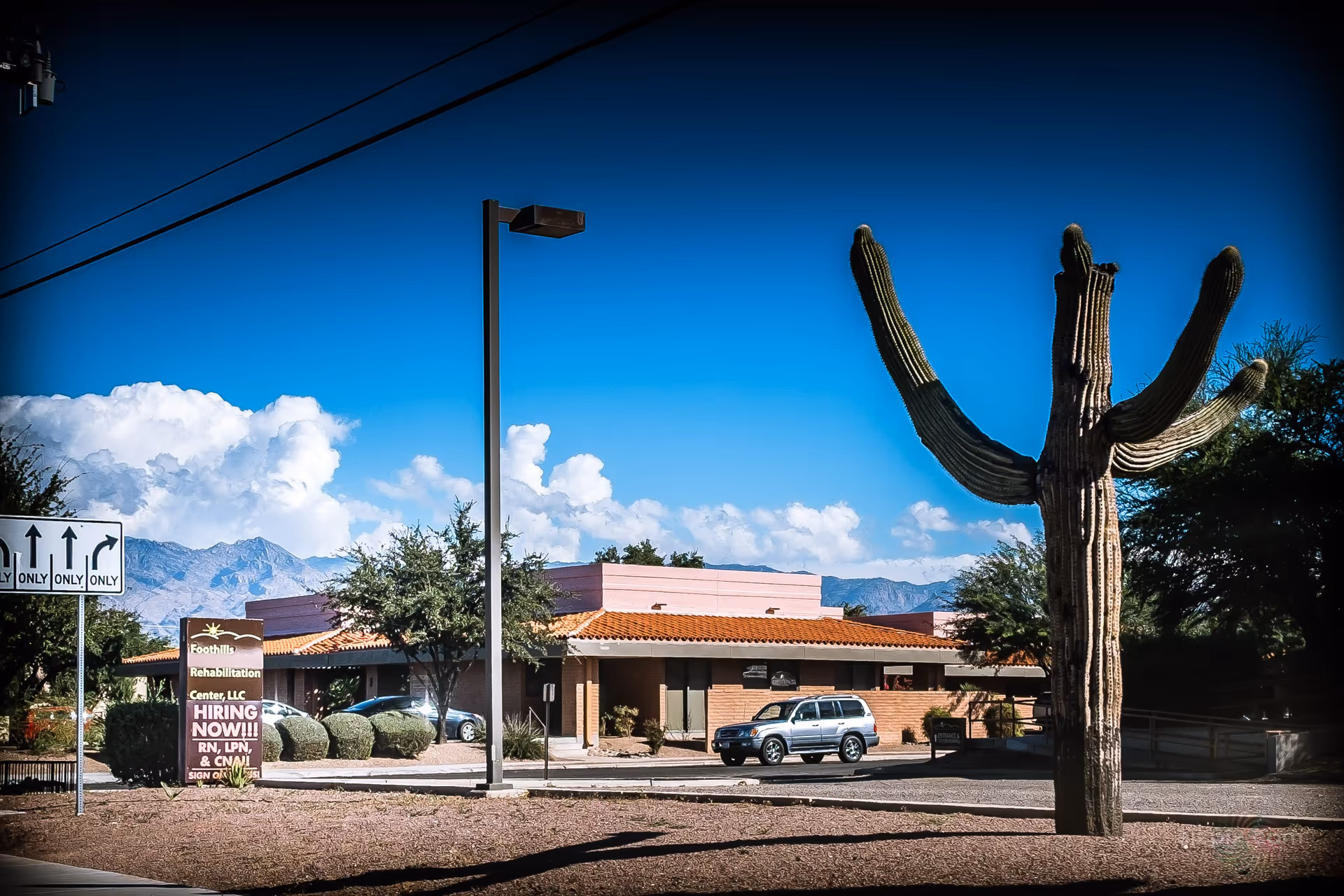 External view of Foothills Rehabilitation Center with a large cactus and desert mountains behind.