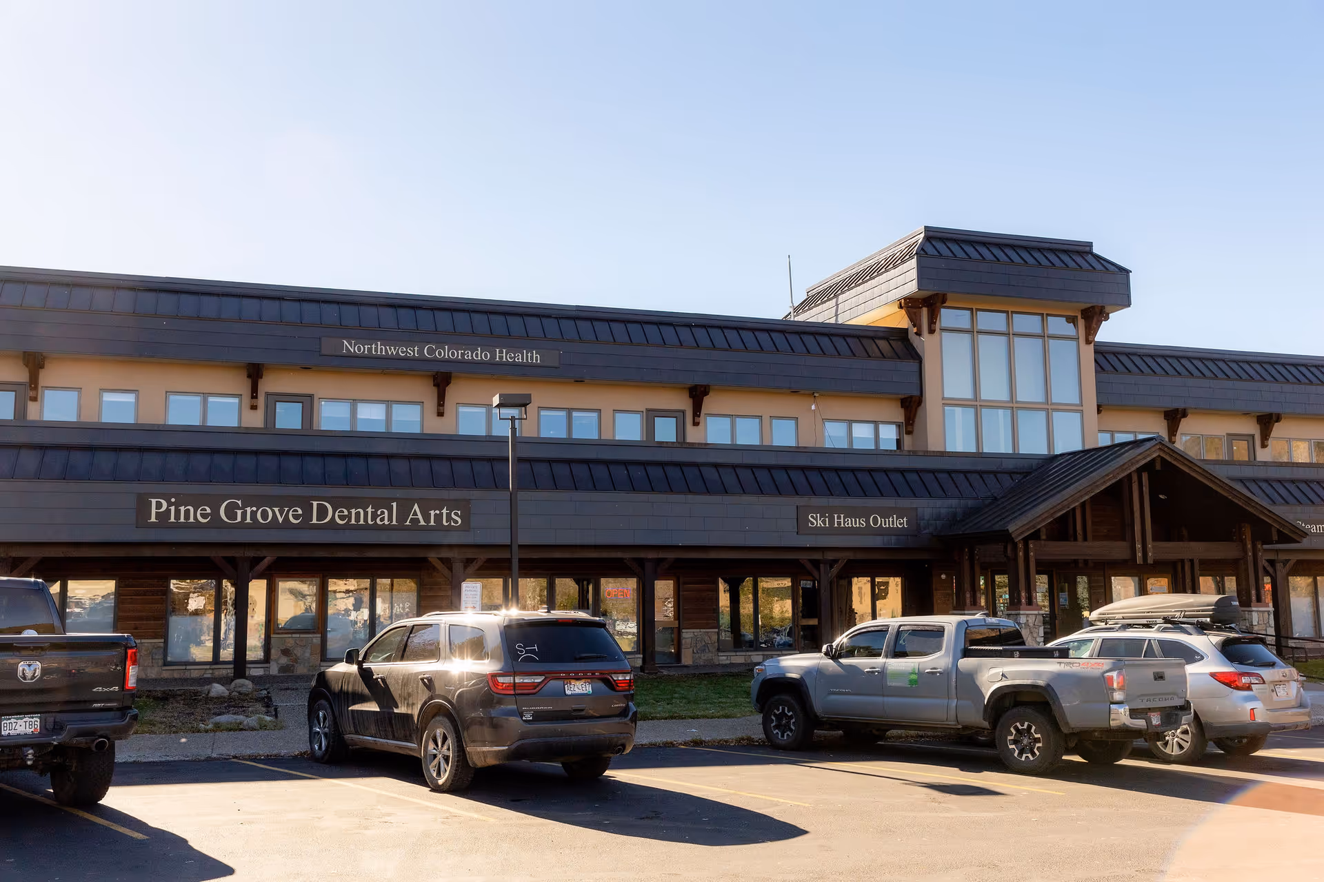 Exterior view of Northwest Colorado Health and Pine Grove Dental Arts with parked cars.