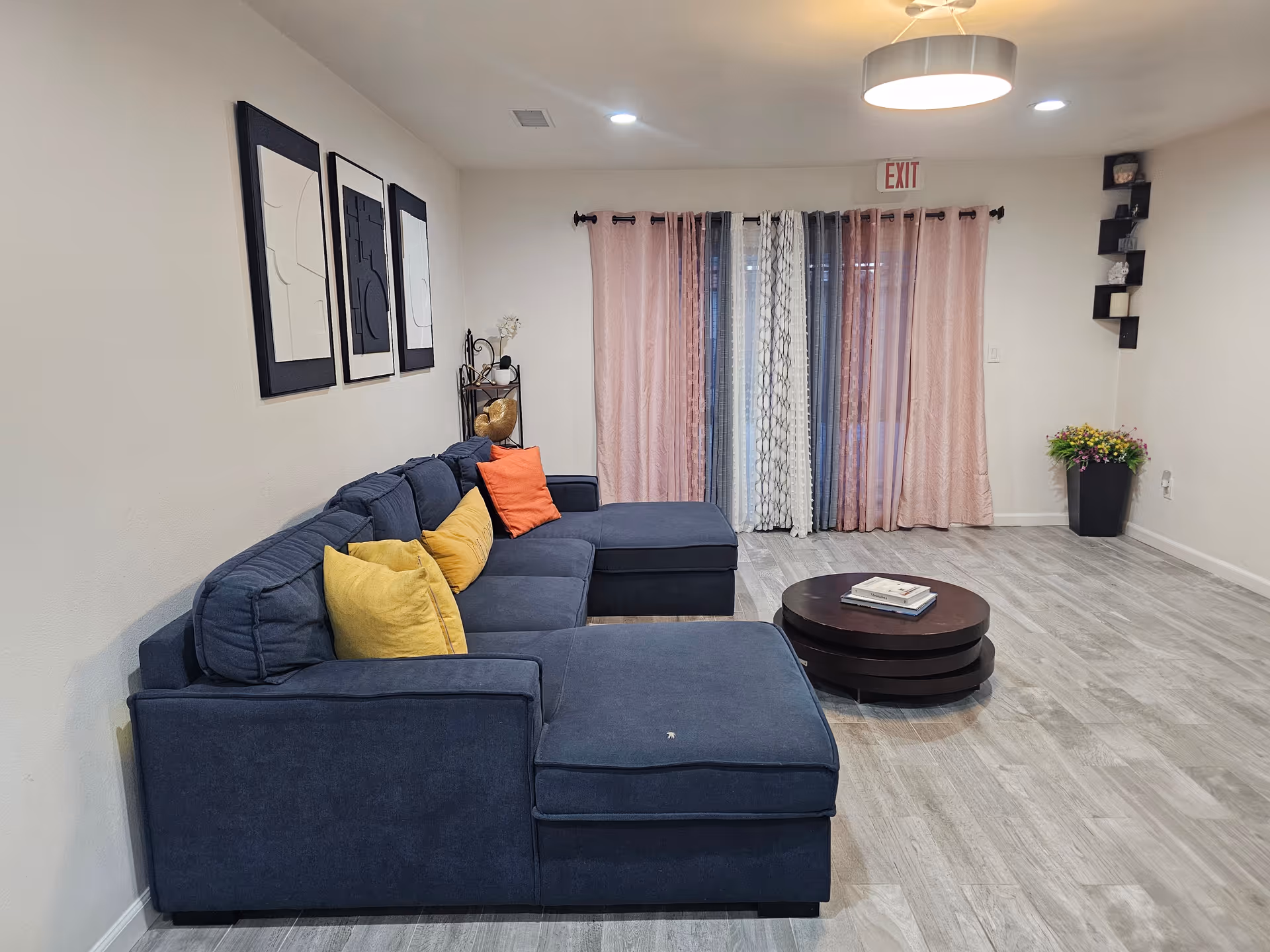 Blue sectional sofa with colorful pillows sits in a modern living room.