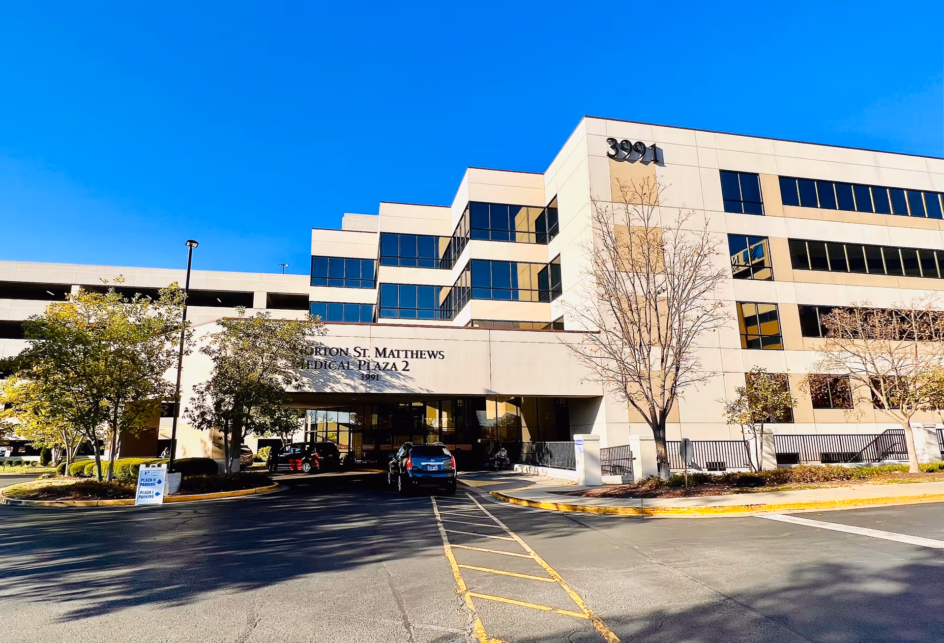 Modern medical plaza building with parking and entrance signage reading Norton St. Matthews Medical Plaza 2.