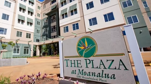 Exterior view of The Plaza at Moanalua with a large entrance sign and multi-story building.