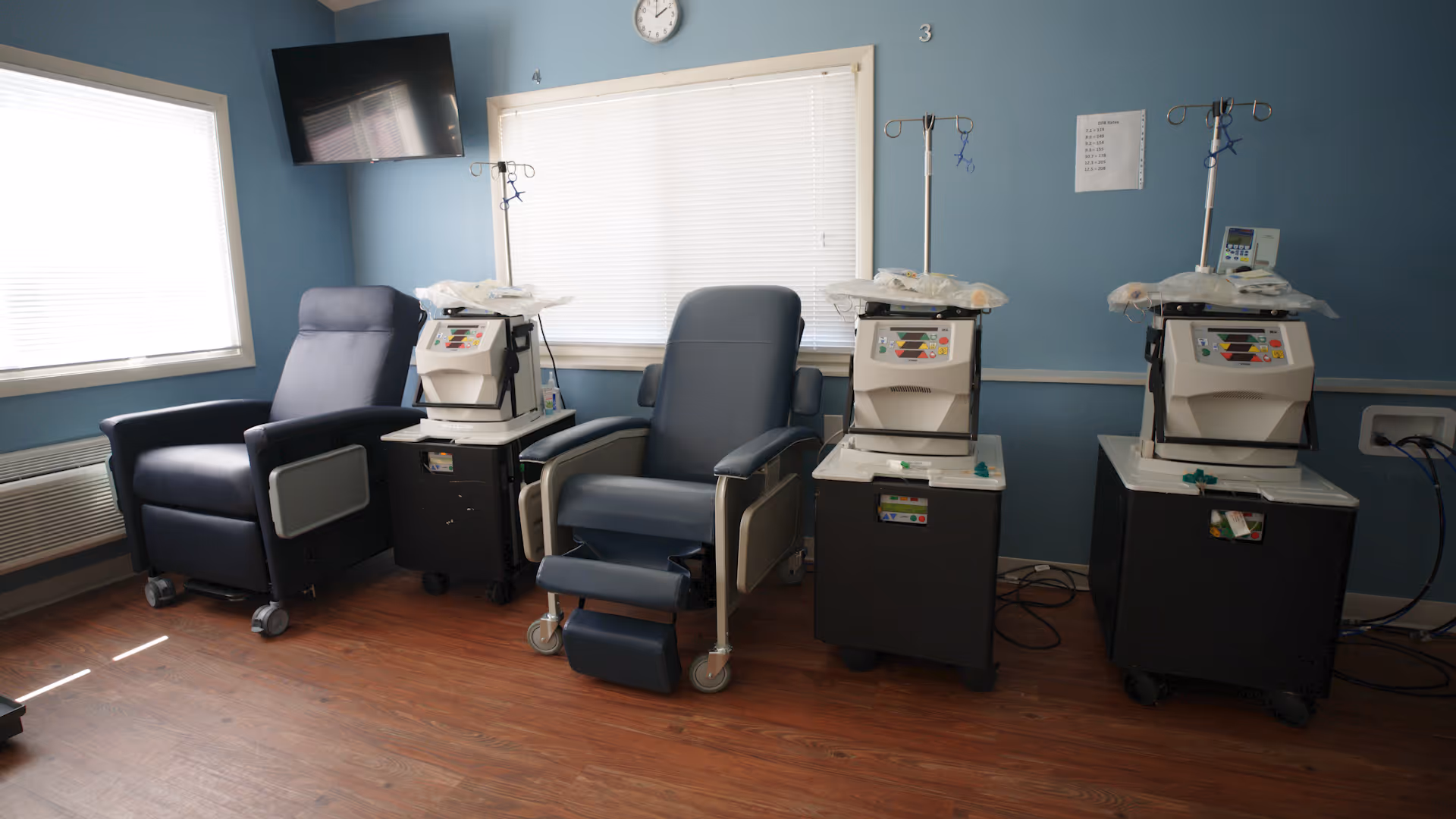 A treatment room in a senior facility featuring reclining chairs and IV infusion machines.