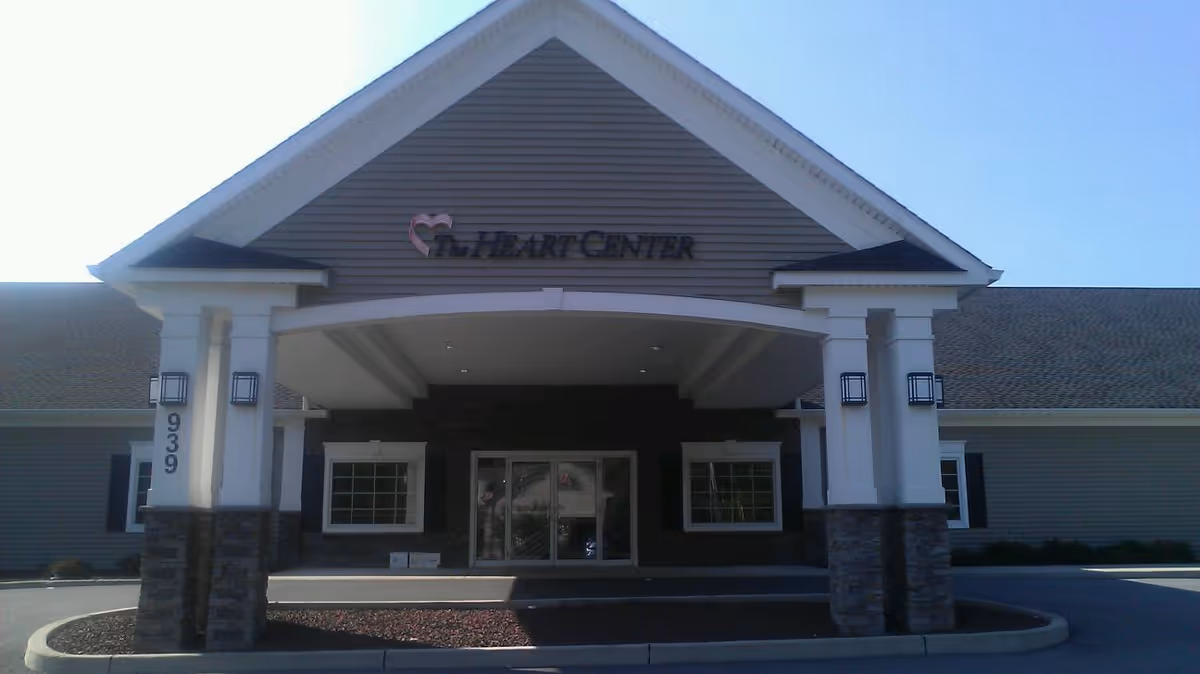 Front view of The Heart Center entrance with white pillars and a peaked roof.