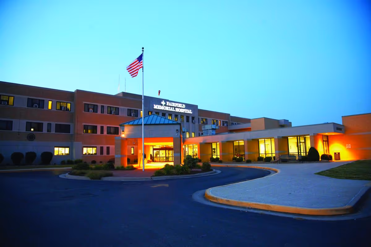 Exterior view of Fairfield Memorial Hospital at dusk with an American flag.