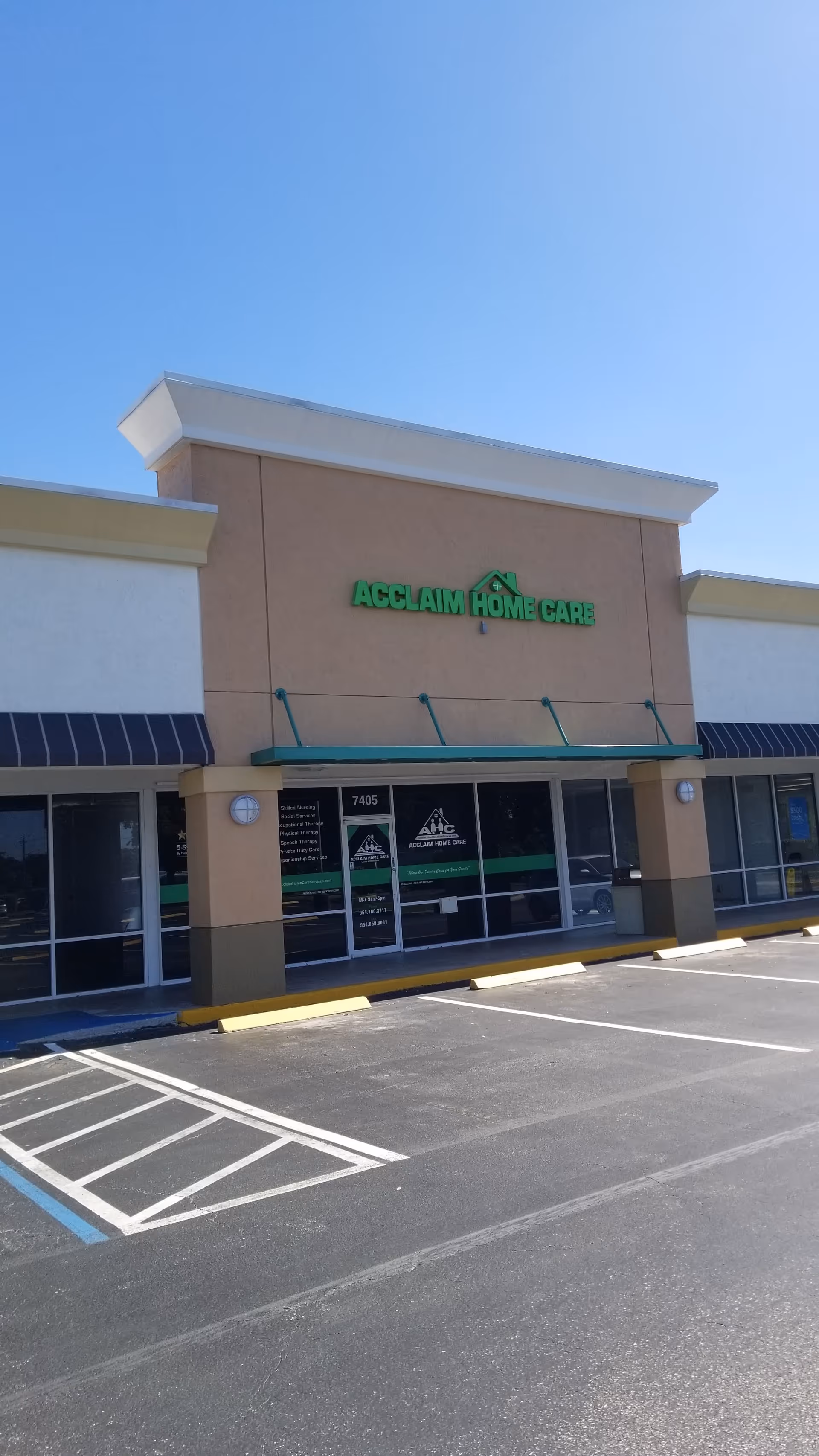 Exterior of Acclaim Home Care storefront, beige building with glass doors, signage, and a parking lot.