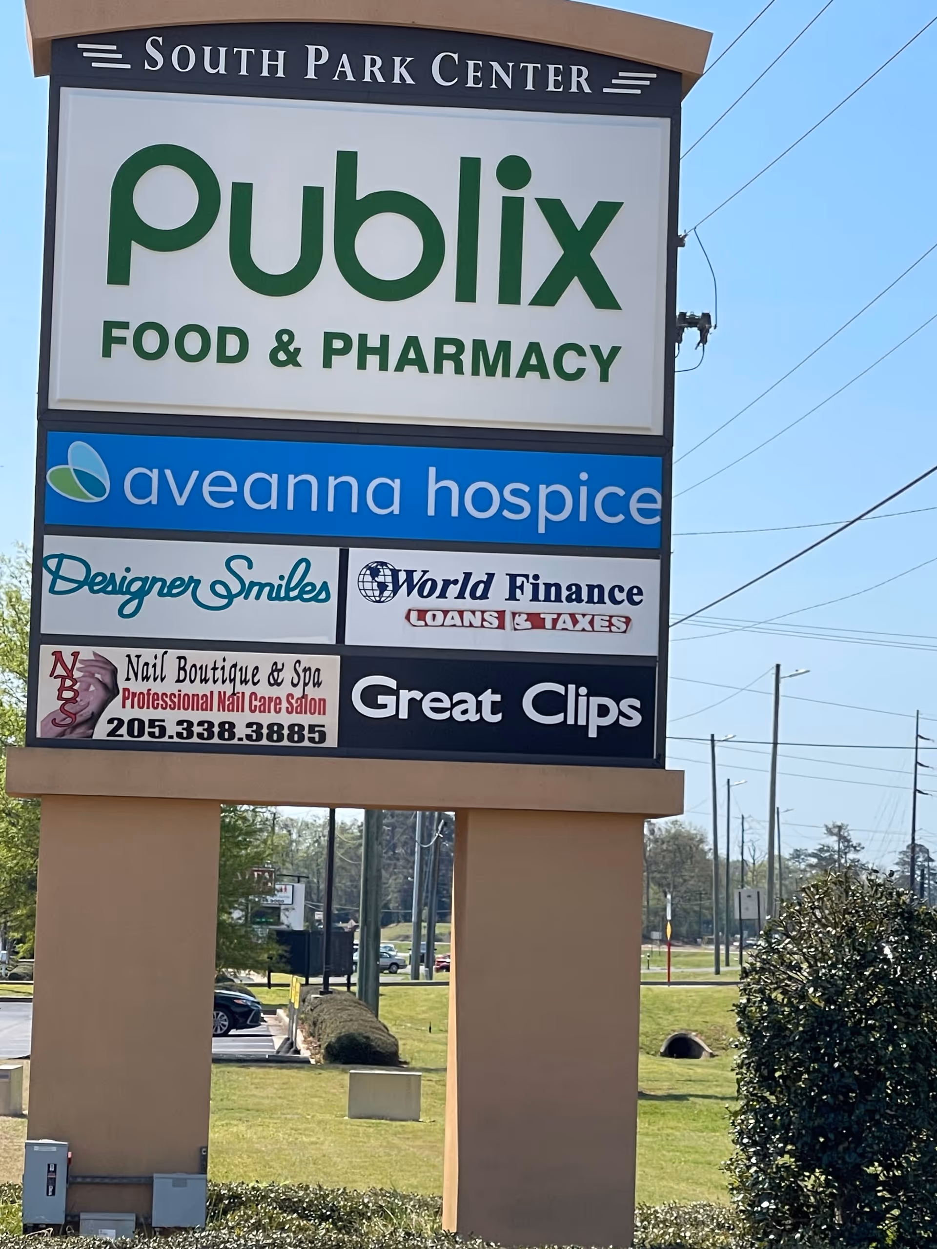 Tall sign outside a shopping center featuring Publix and Aveanna Hospice.