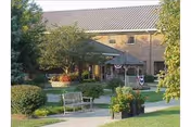 Exterior view of Thomson-Hood Veterans Center with benches and landscaped front lawn.