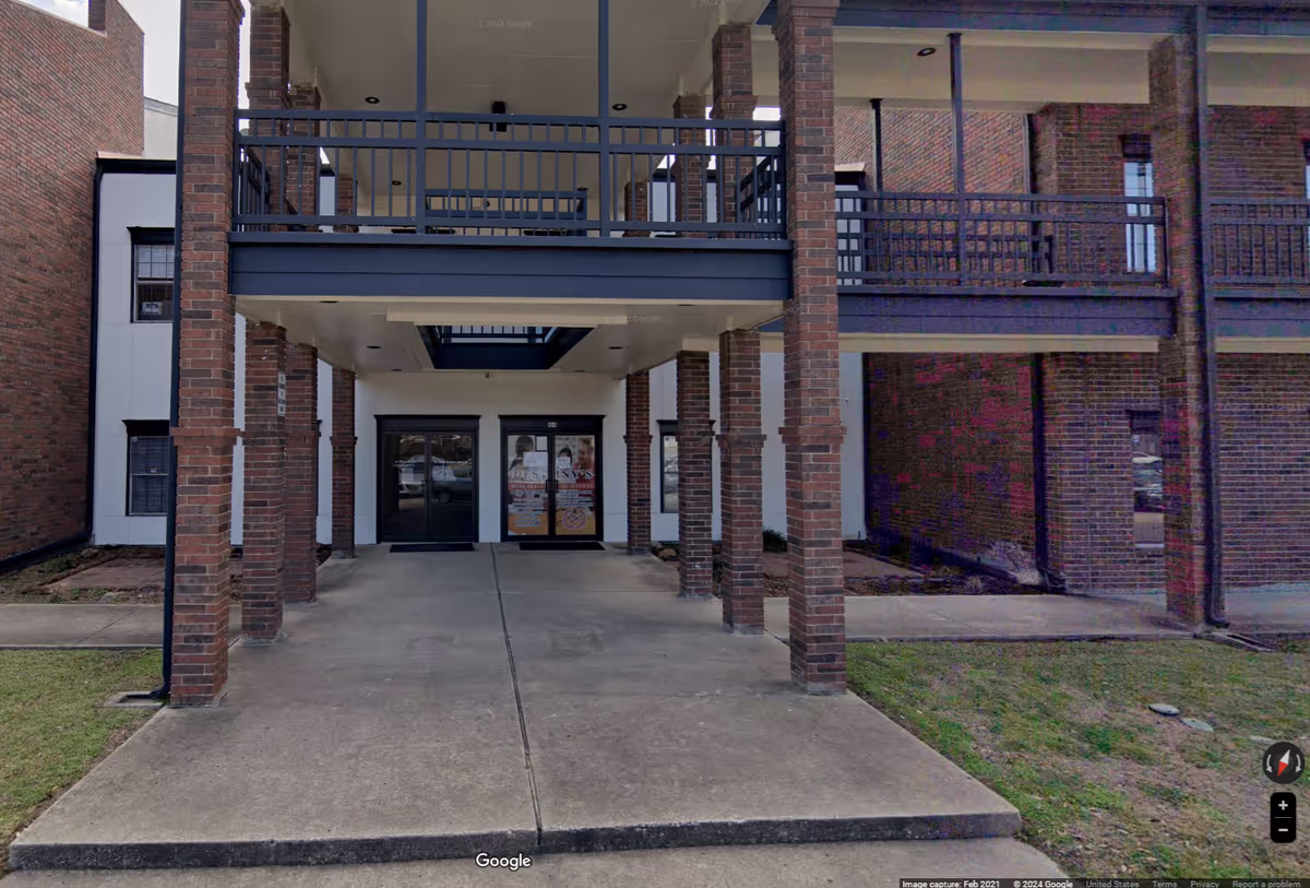 Brick building entrance with covered walkway and glass doors, Destiny's Home Health Care sign.